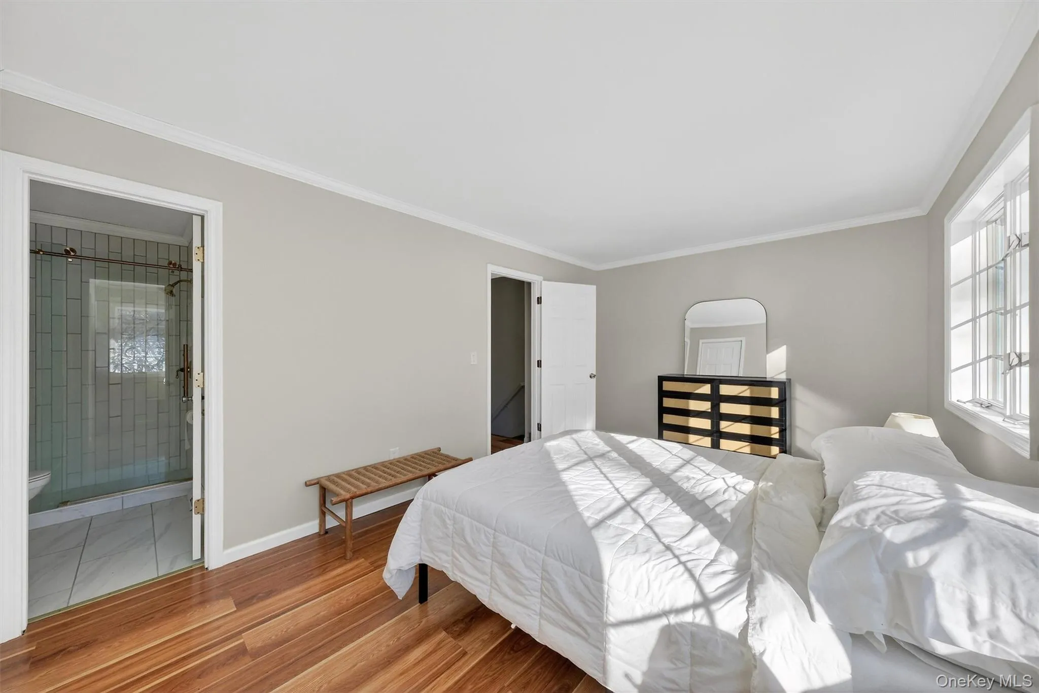Bedroom featuring wood finished floors and ornamental molding Bedroom featuring wood finished floors and ornamental molding