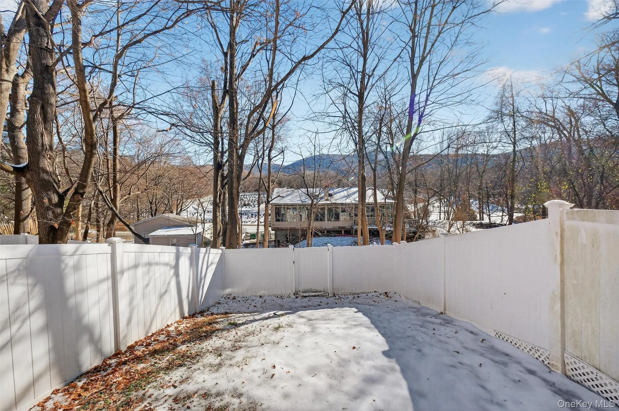 Snowy yard featuring a fenced backyard and a mountain view Snowy yard featuring a fenced backyard and a mountain view