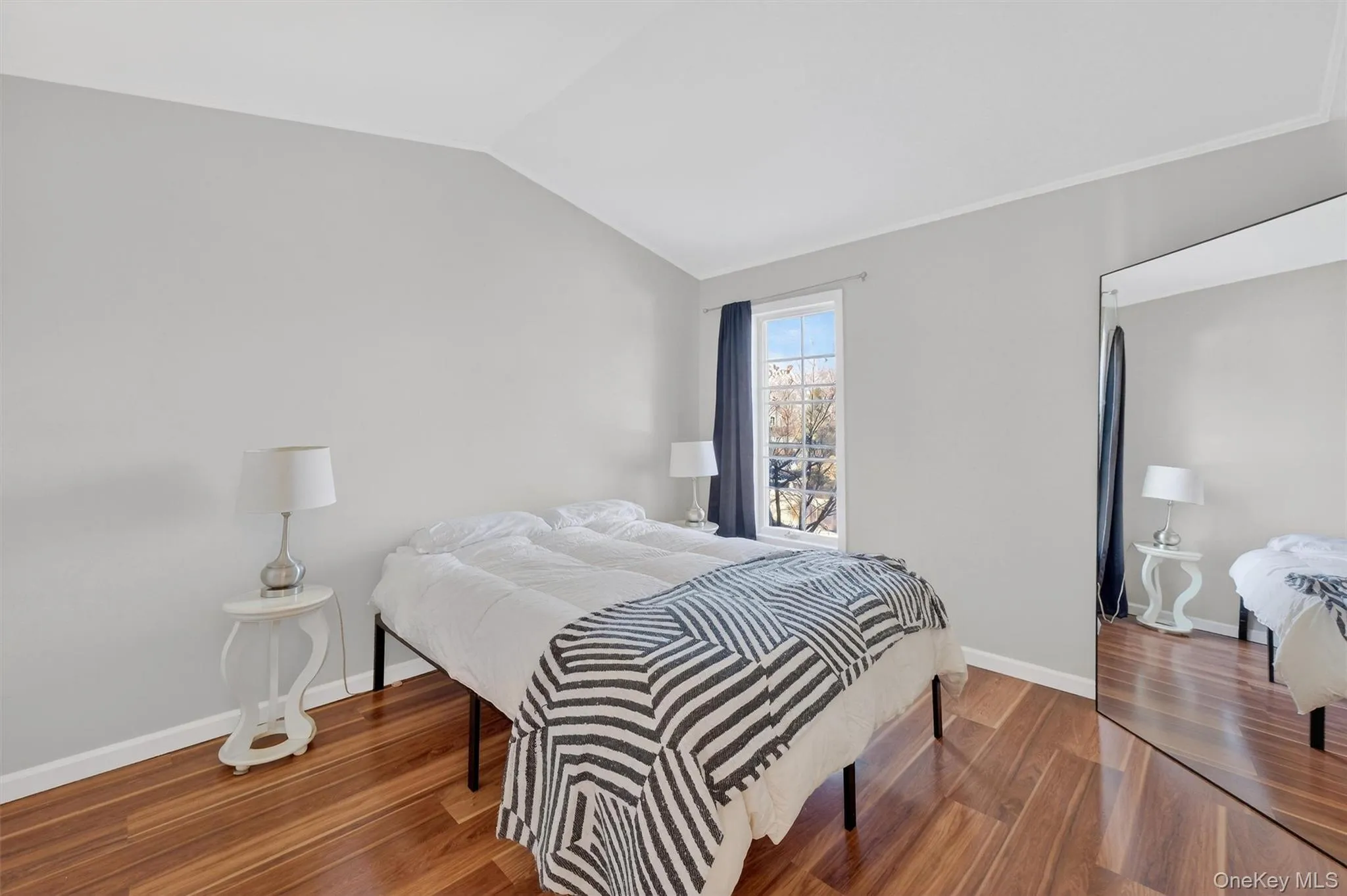 Bedroom with wood finished floors and vaulted ceiling Bedroom with wood finished floors and vaulted ceiling