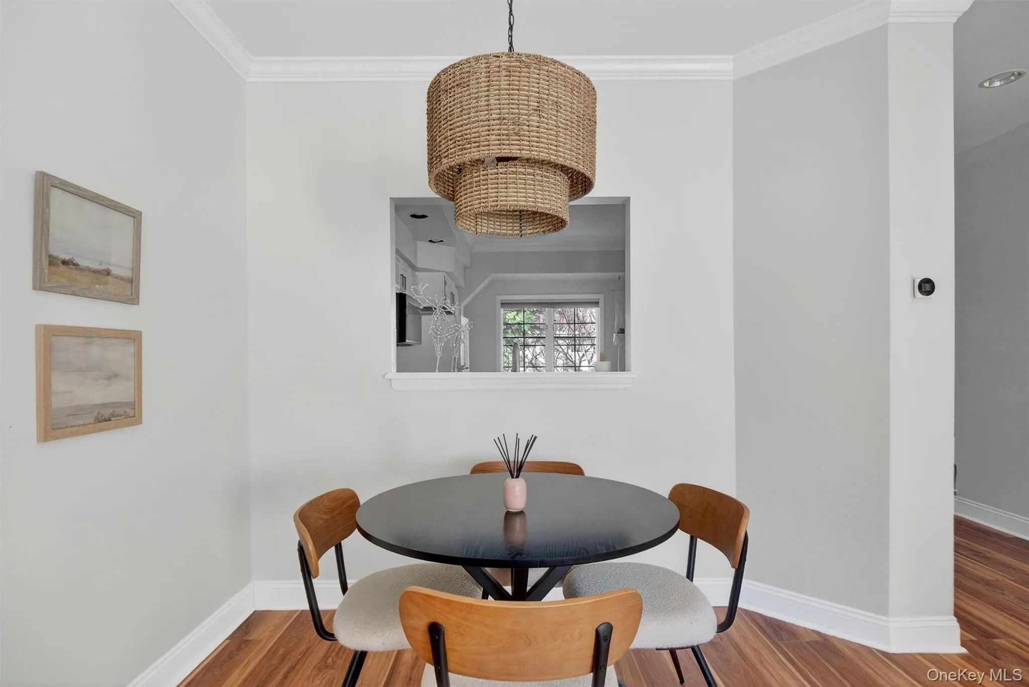 Dining space featuring ornamental molding, wood finished floors, and a chandelier Dining space featuring ornamental molding, wood finished floors, and a chandelier