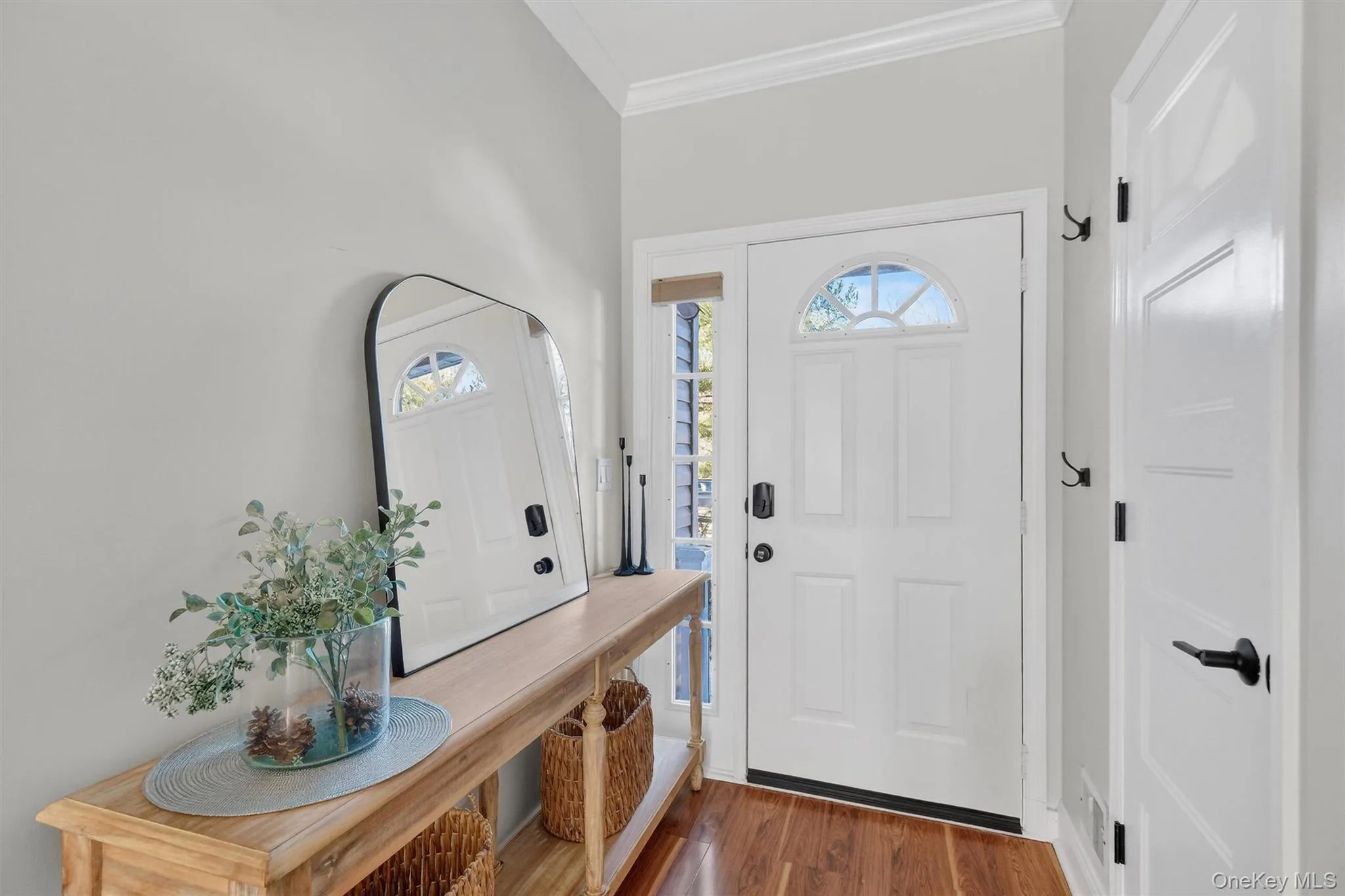 Foyer entrance with dark wood-style flooring, crown molding, and plenty of natural light Foyer entrance with dark wood-style flooring, crown molding, and plenty of natural light