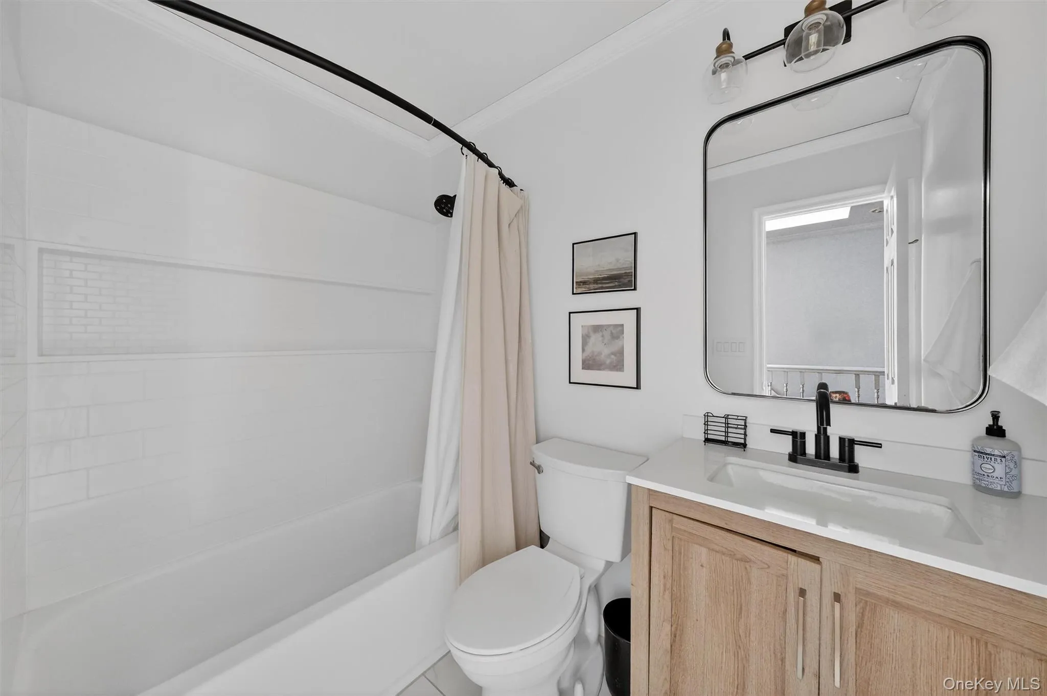 Full bath featuring shower / tub combo with curtain, vanity, and ornamental molding Full bath featuring shower / tub combo with curtain, vanity, and ornamental molding