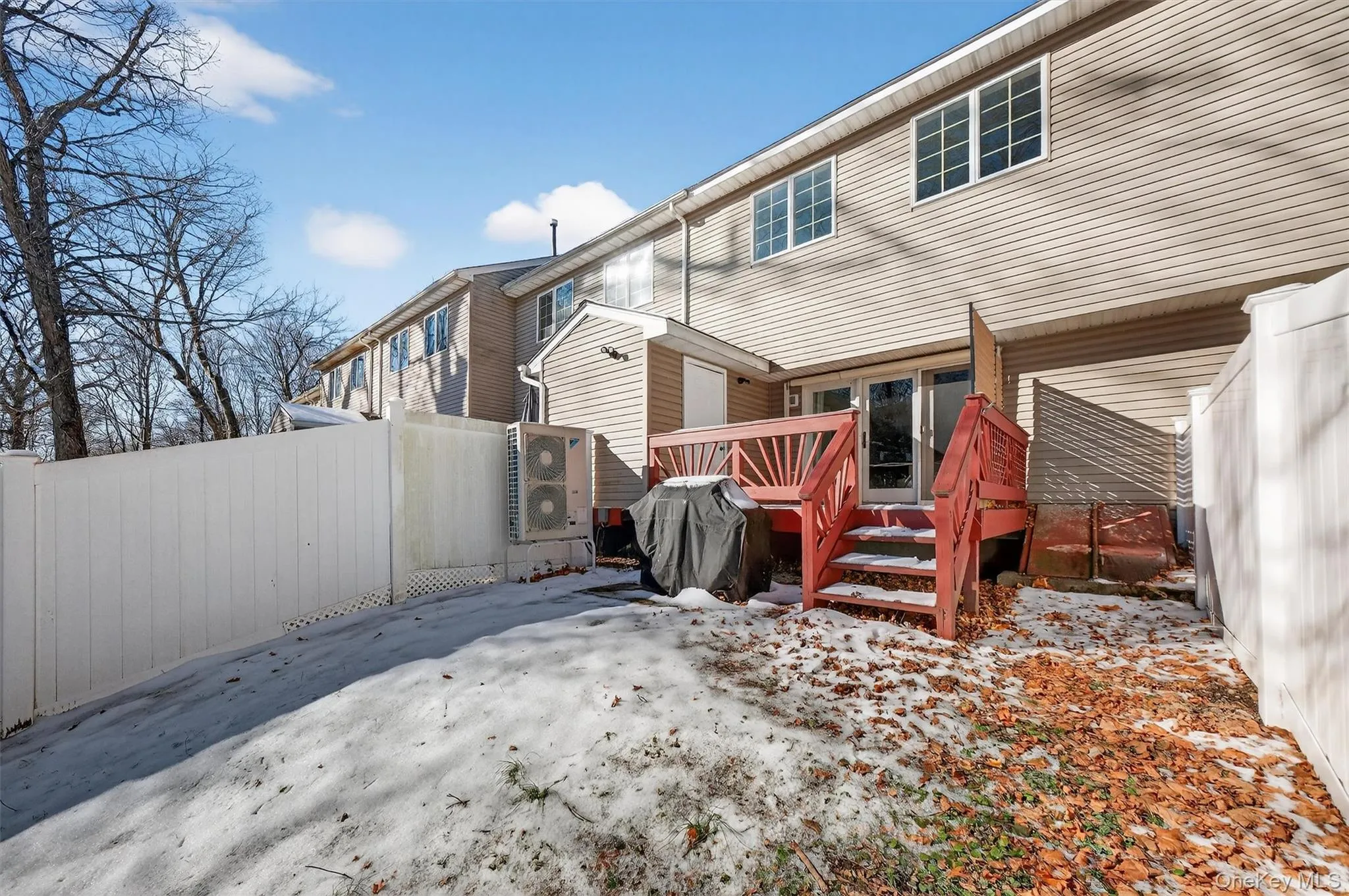 Snow covered back of property featuring a fenced backyard and a deck Snow covered back of property featuring a fenced backyard and a deck