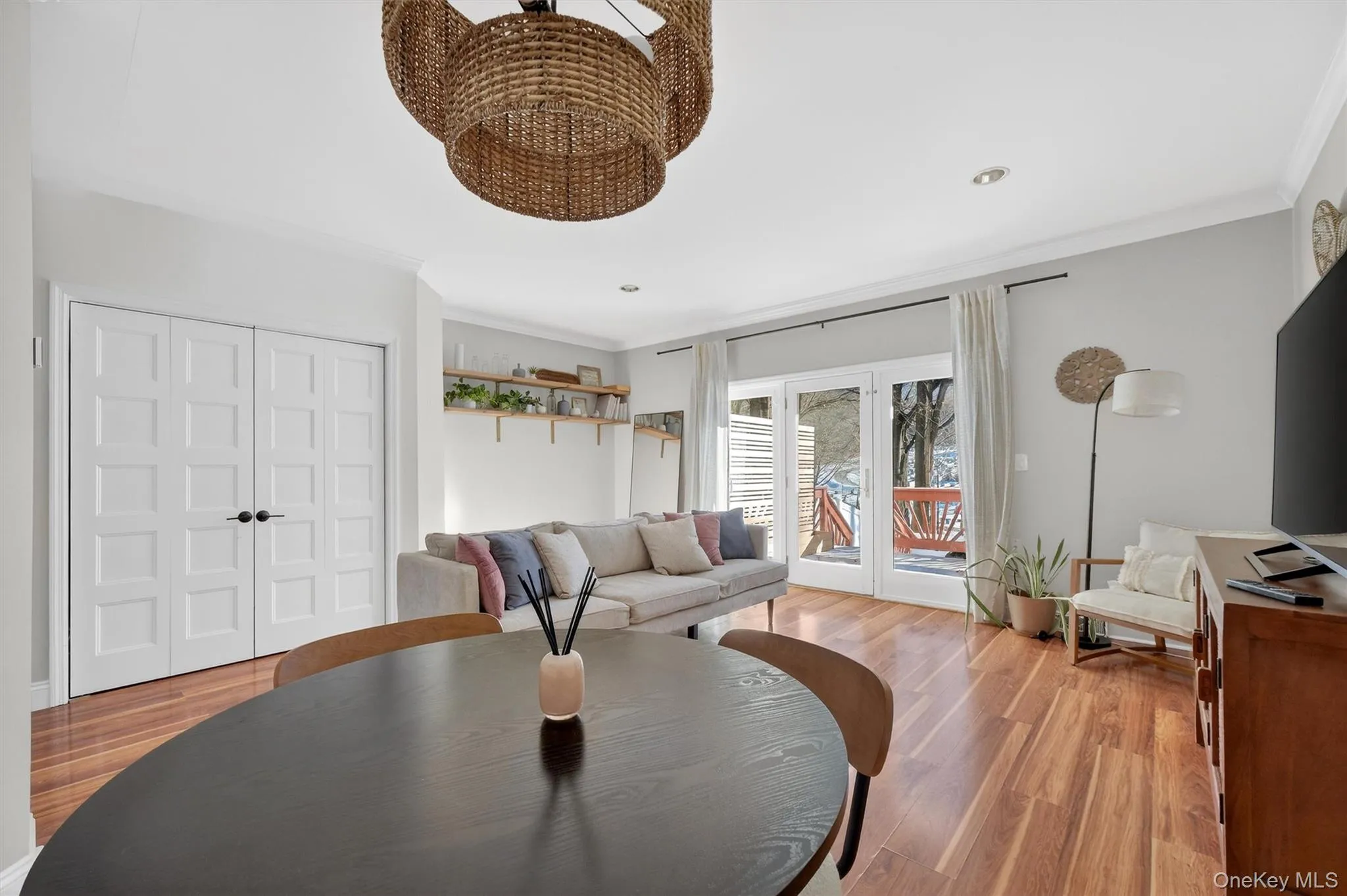 Living room with ornamental molding, wood finished floors, french doors, a chandelier, and recessed lighting Living room with ornamental molding, wood finished floors, french doors, a chandelier, and recessed lighting