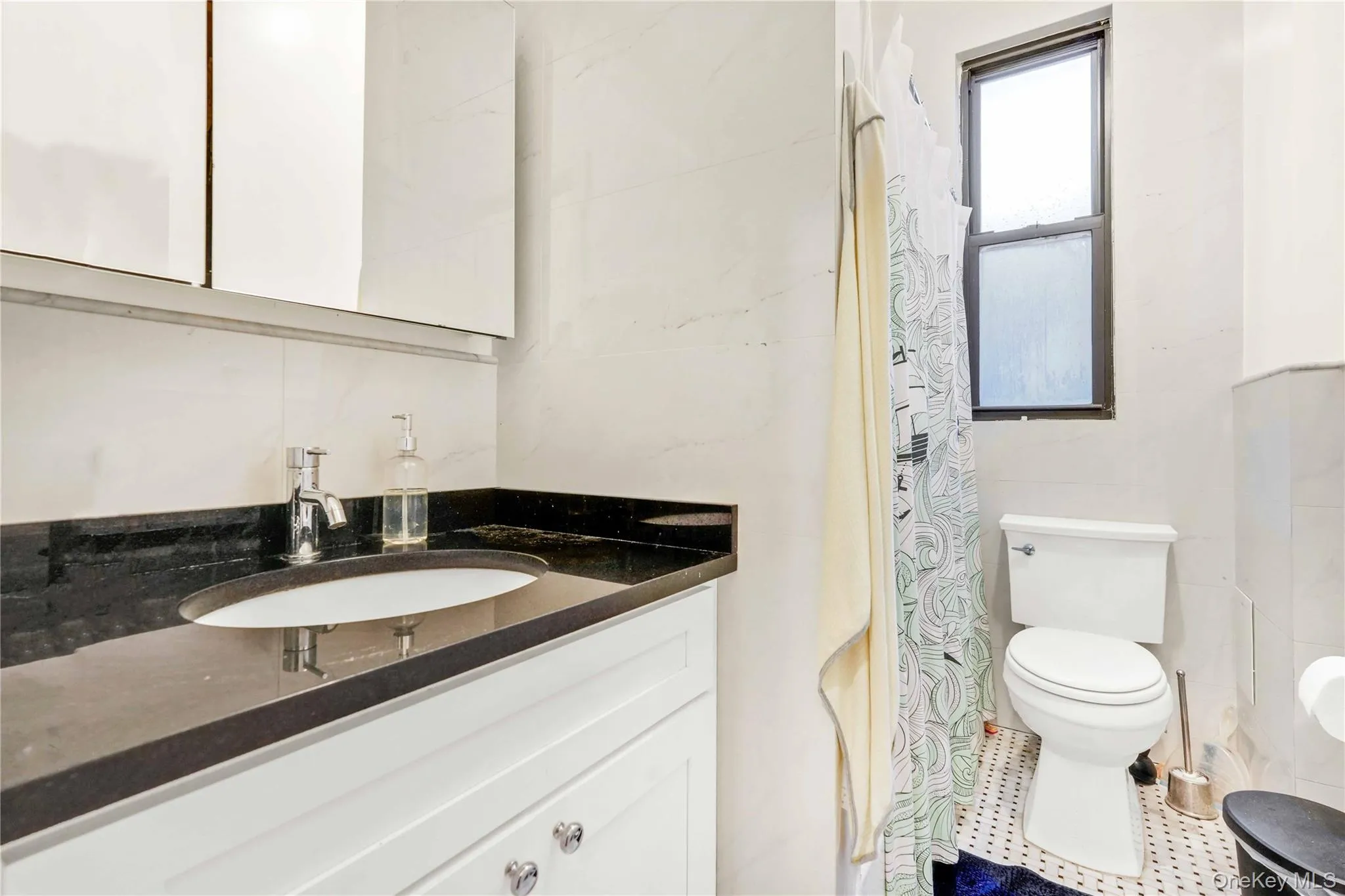 Bathroom with vanity, a shower with curtain, and tile walls Bathroom with vanity, a shower with curtain, and tile walls