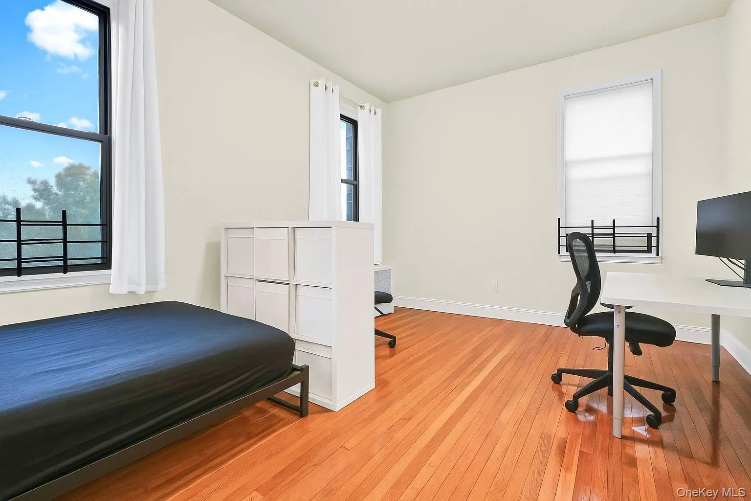 Bedroom with a desk and light wood-type flooring Bedroom with a desk and light wood-type flooring