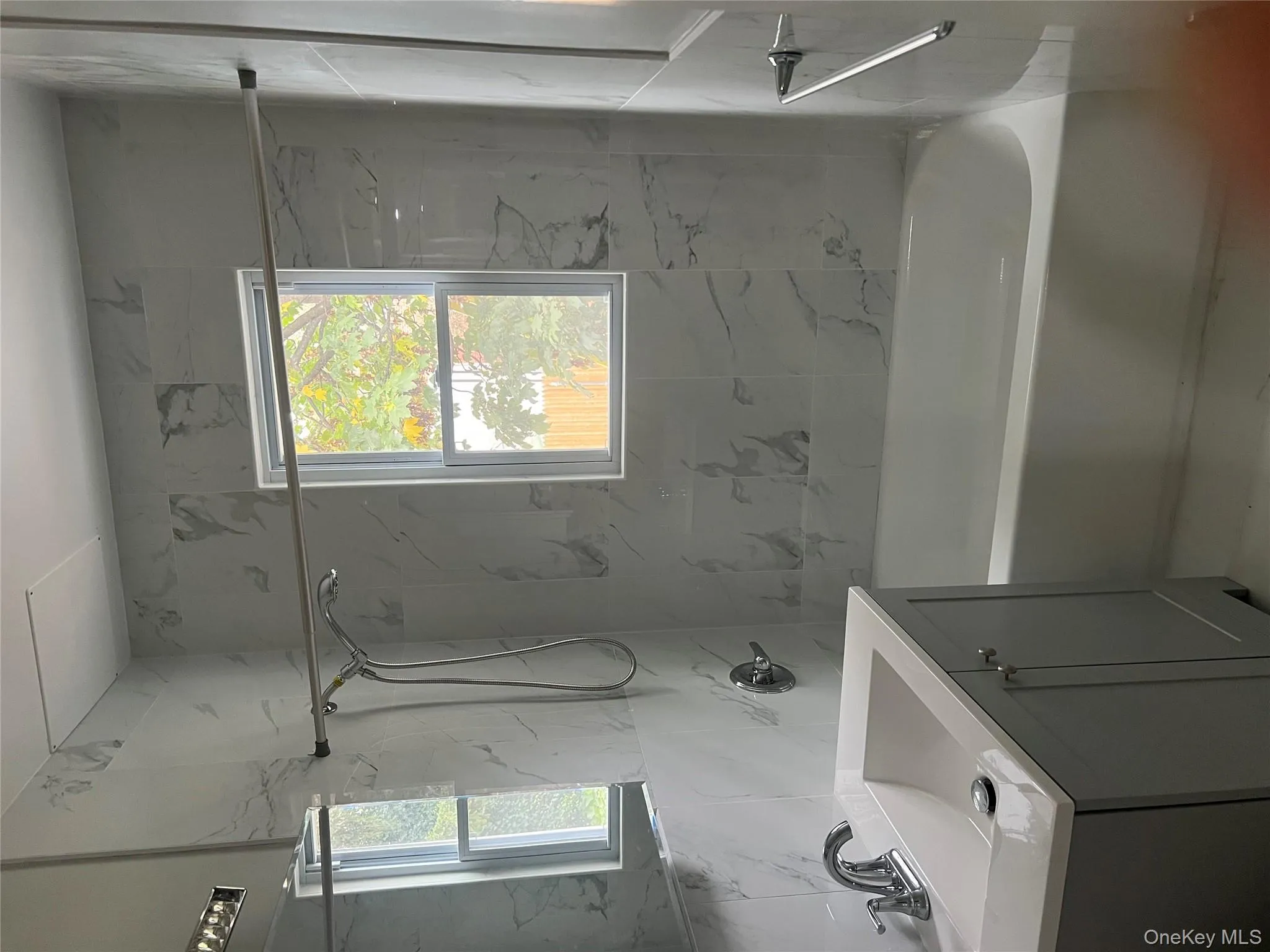 Bathroom featuring vanity, shower / washtub combination, and tile walls Bathroom featuring vanity, shower / washtub combination, and tile walls