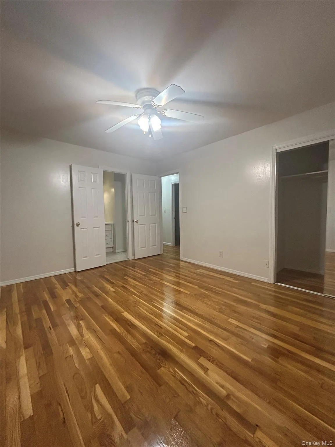 Unfurnished bedroom featuring dark wood finished floors, ceiling fan, and a closet Unfurnished bedroom featuring dark wood finished floors, ceiling fan, and a closet