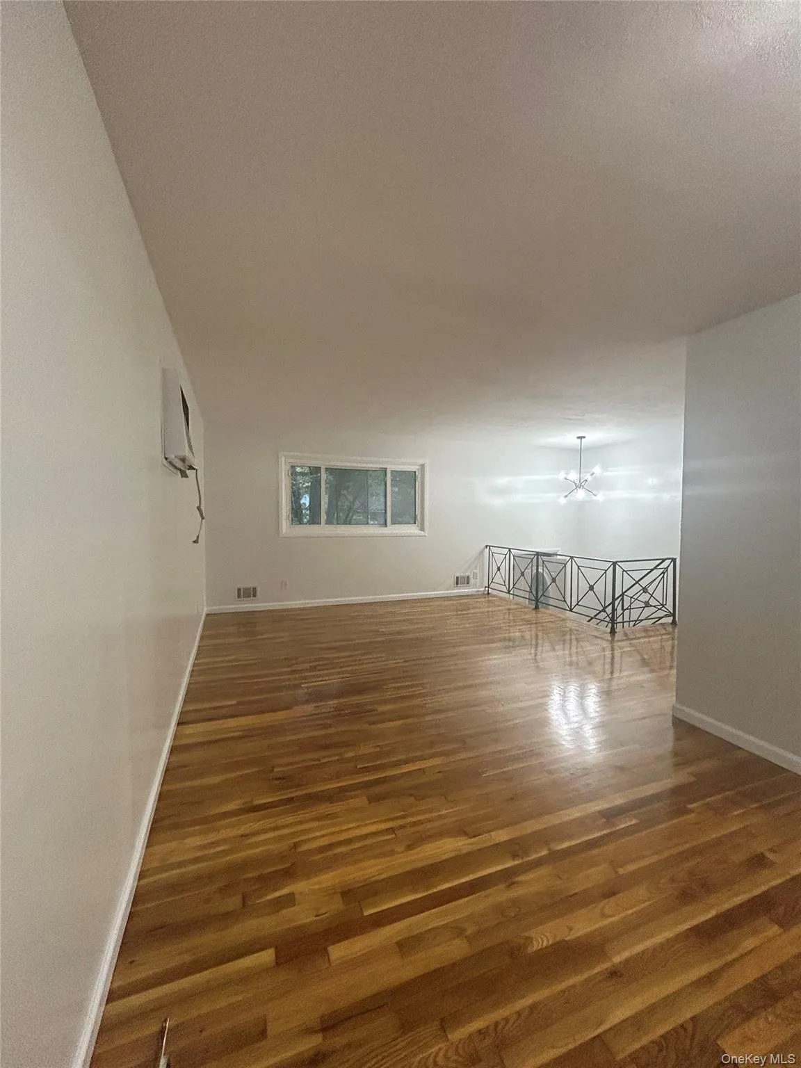 Empty room featuring wood finished floors and baseboards Empty room featuring wood finished floors and baseboards