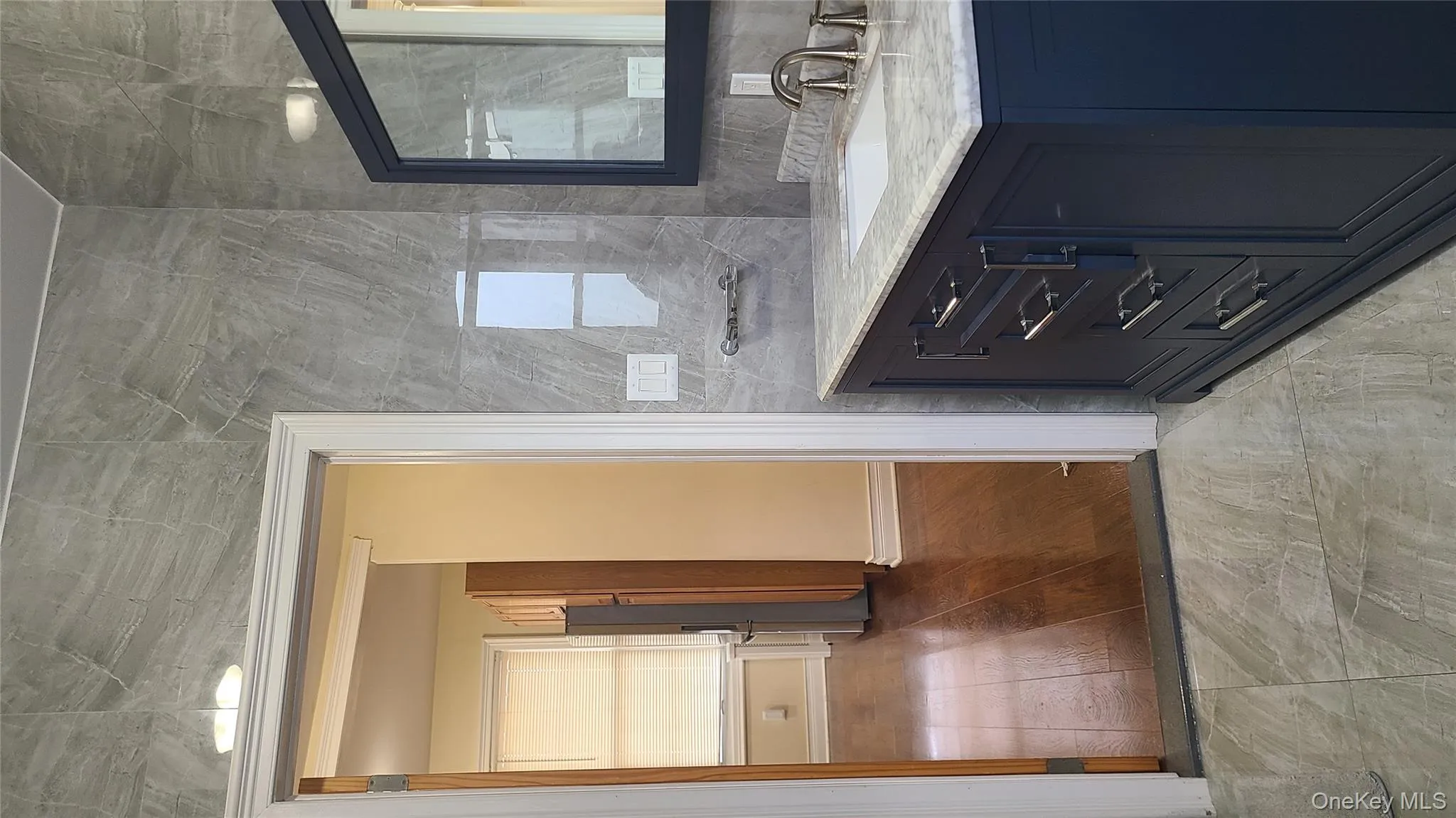 Bathroom featuring tile walls, vanity, and light wood finished floors Bathroom featuring tile walls, vanity, and light wood finished floors
