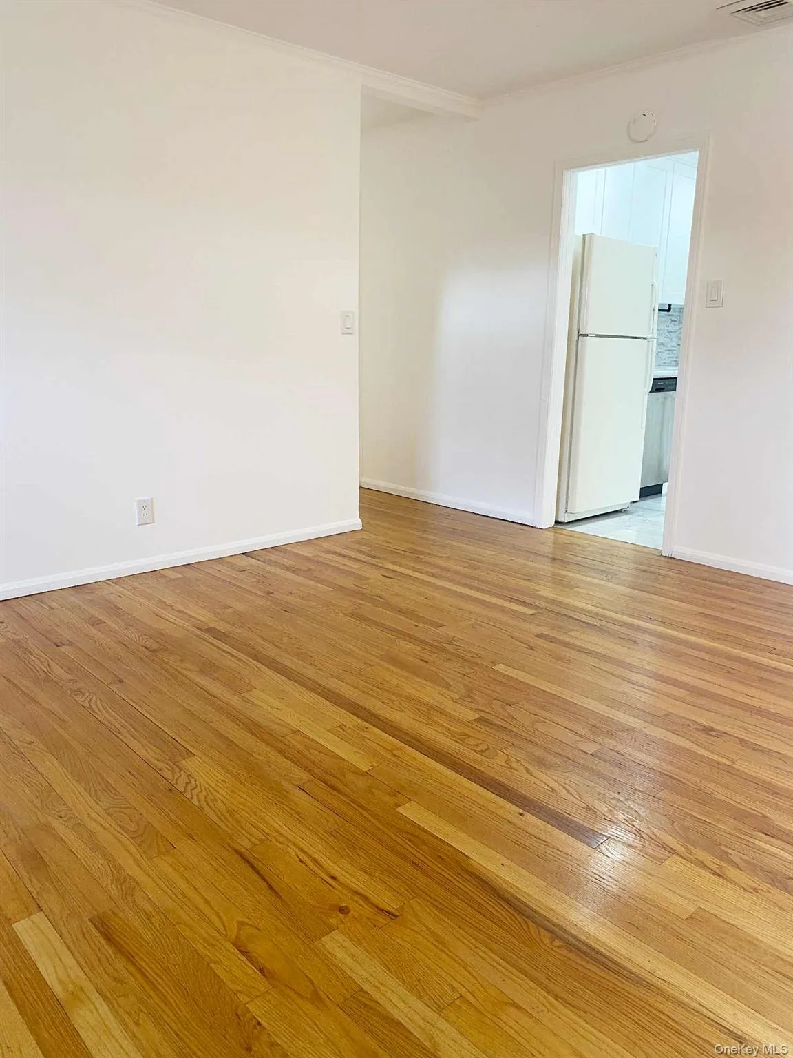 Empty room with light wood-style floors and ornamental molding Empty room with light wood-style floors and ornamental molding
