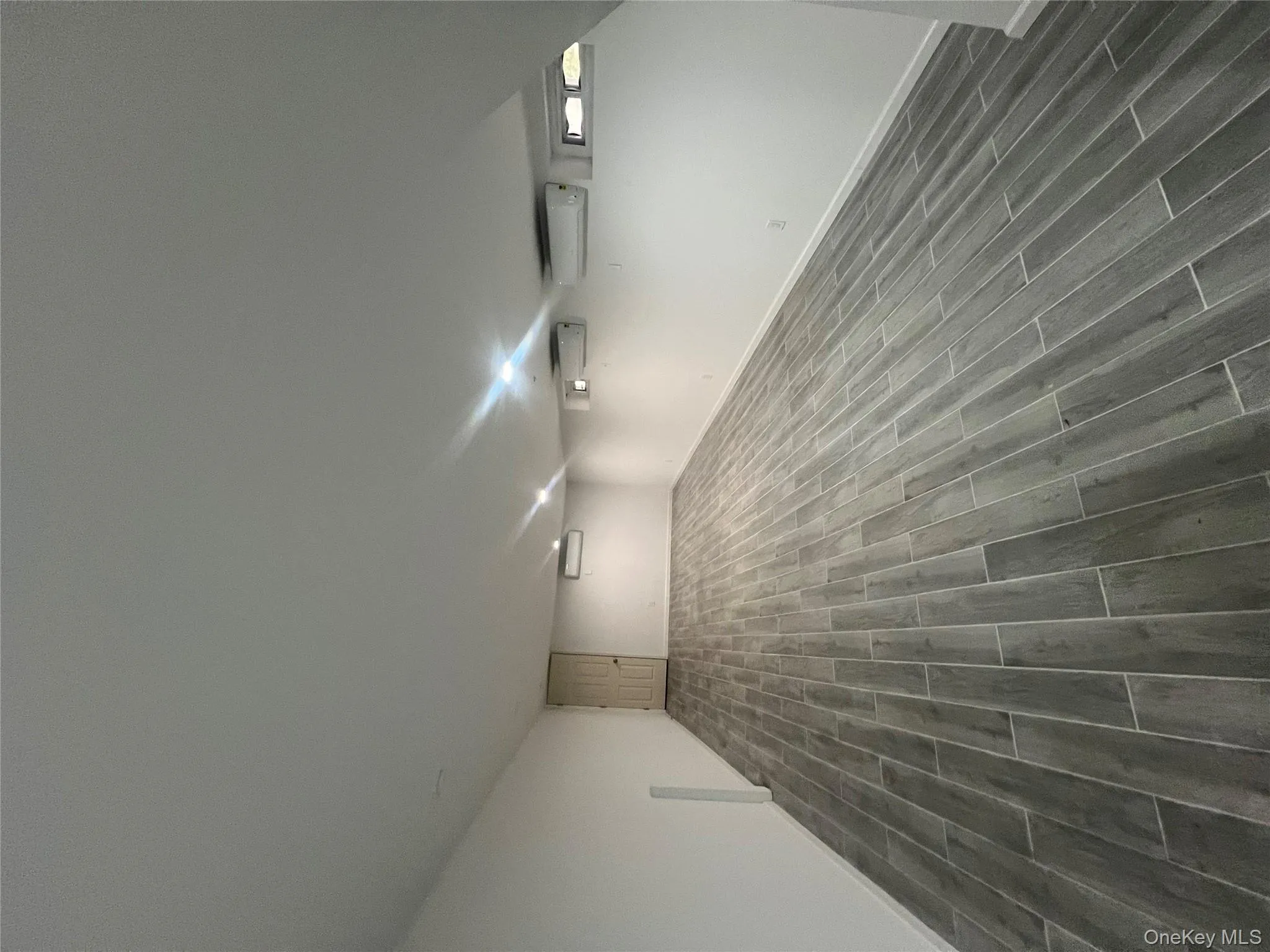 Finished basement featuring wood finish floors and an AC wall unit Finished basement featuring wood finish floors and an AC wall unit