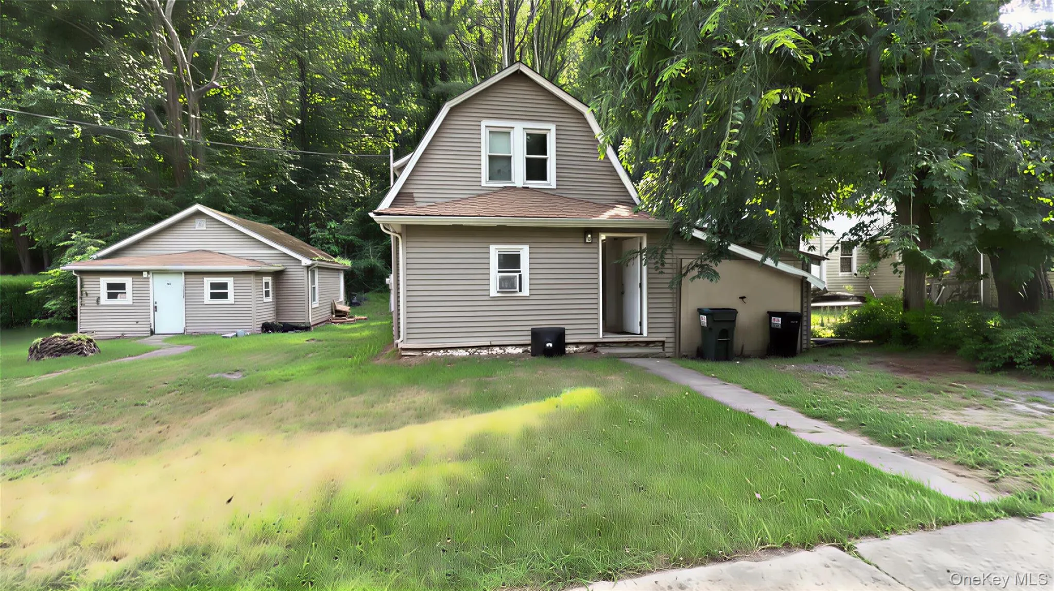 Rear view of property featuring a gambrel roof and a lawn Rear view of property featuring a gambrel roof and a lawn