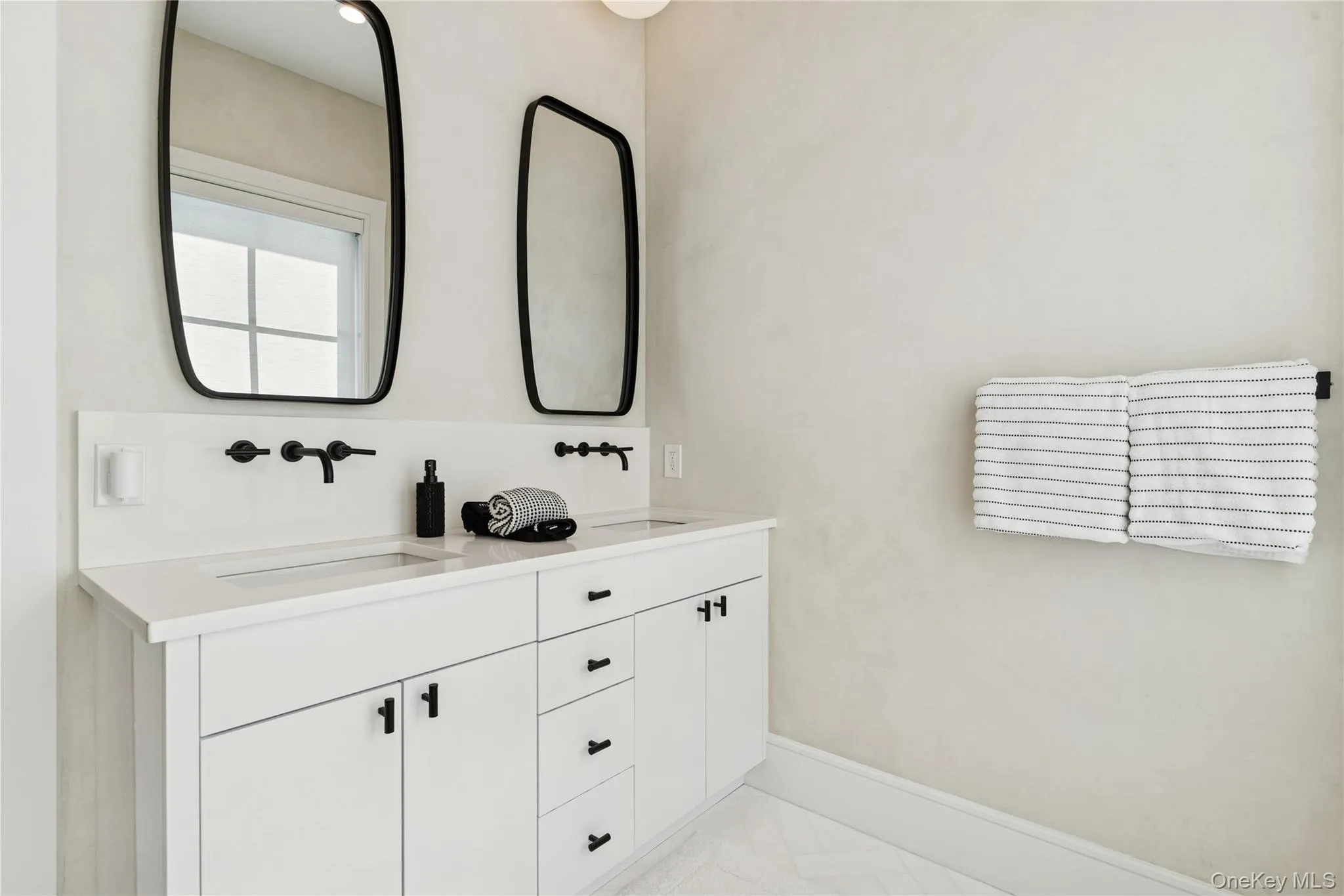 Bathroom with double vanity and baseboards Bathroom with double vanity and baseboards