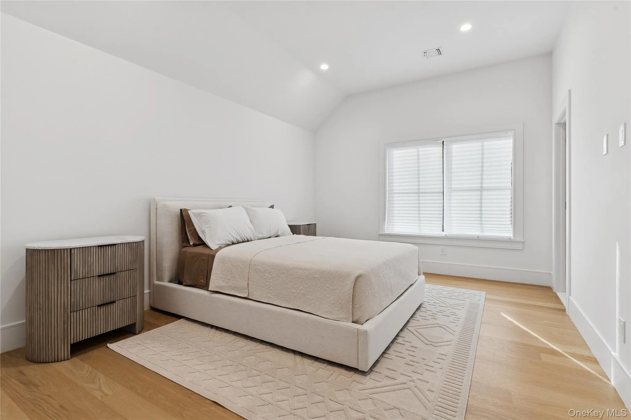 Bedroom featuring light wood-style flooring, recessed lighting, and lofted ceiling Bedroom featuring light wood-style flooring, recessed lighting, and lofted ceiling