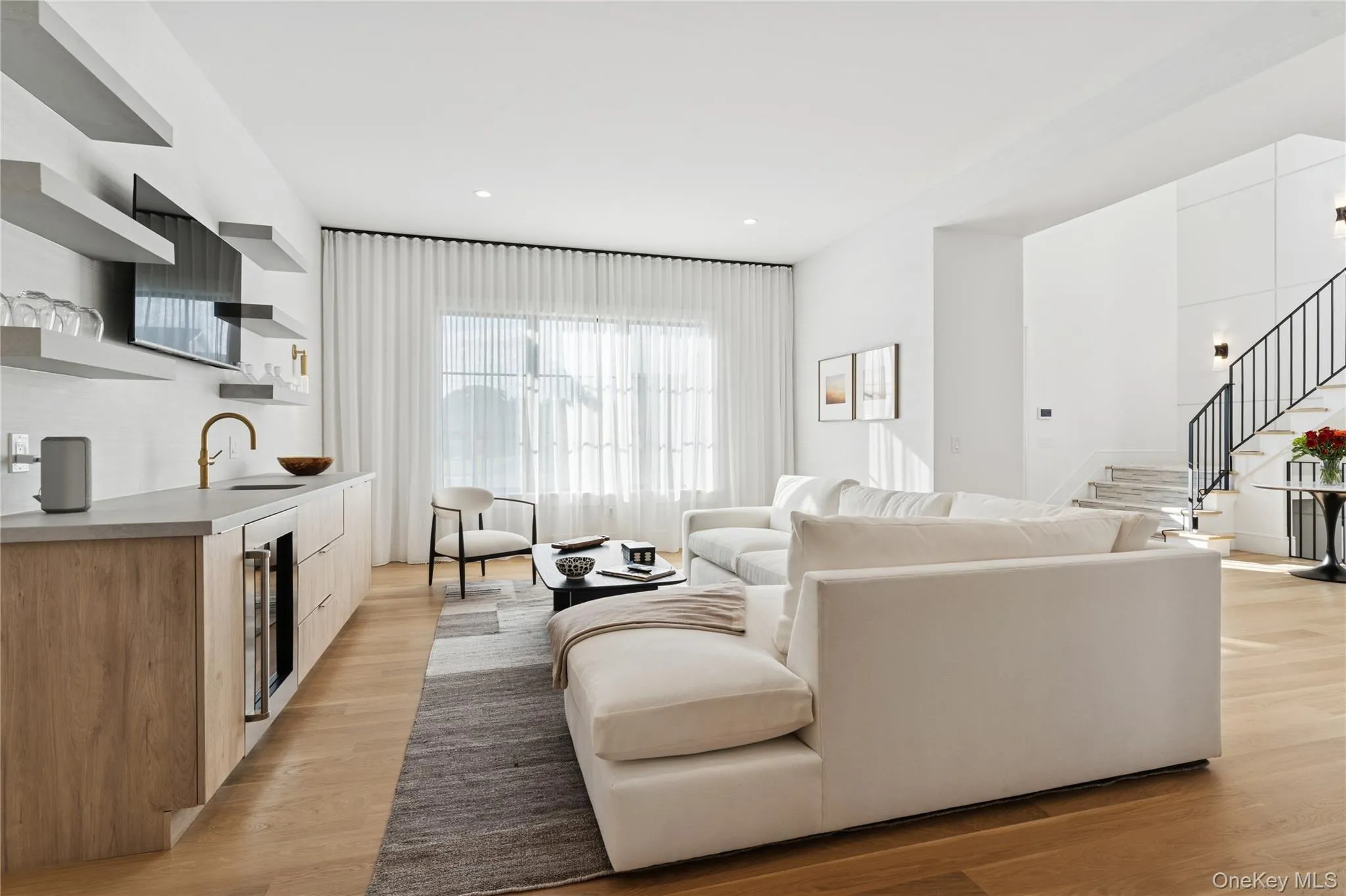 Living area featuring light wood-type flooring, stairway, beverage cooler, and recessed lighting Living area featuring light wood-type flooring, stairway, beverage cooler, and recessed lighting