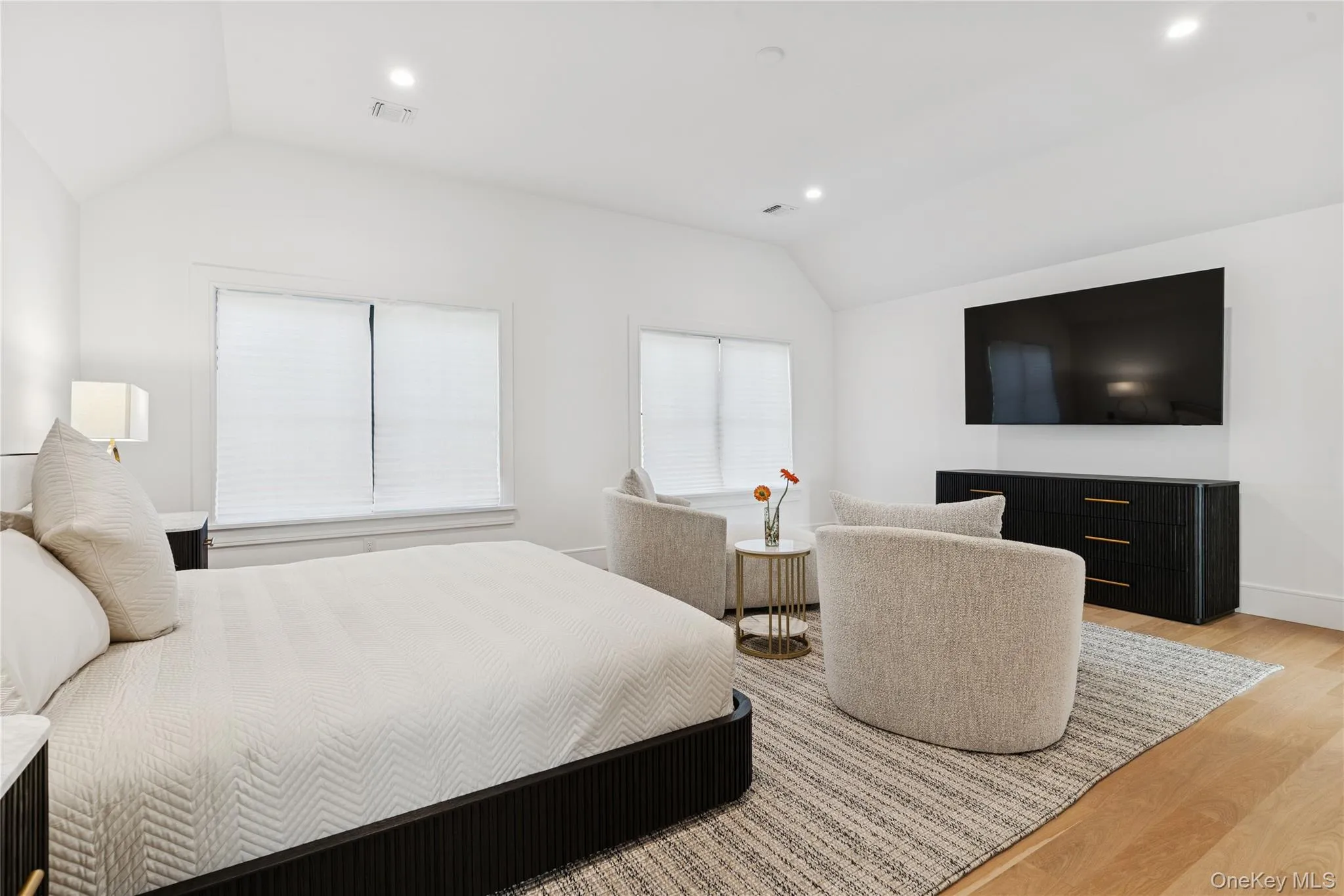 Bedroom with vaulted ceiling, light wood finished floors, and recessed lighting Bedroom with vaulted ceiling, light wood finished floors, and recessed lighting