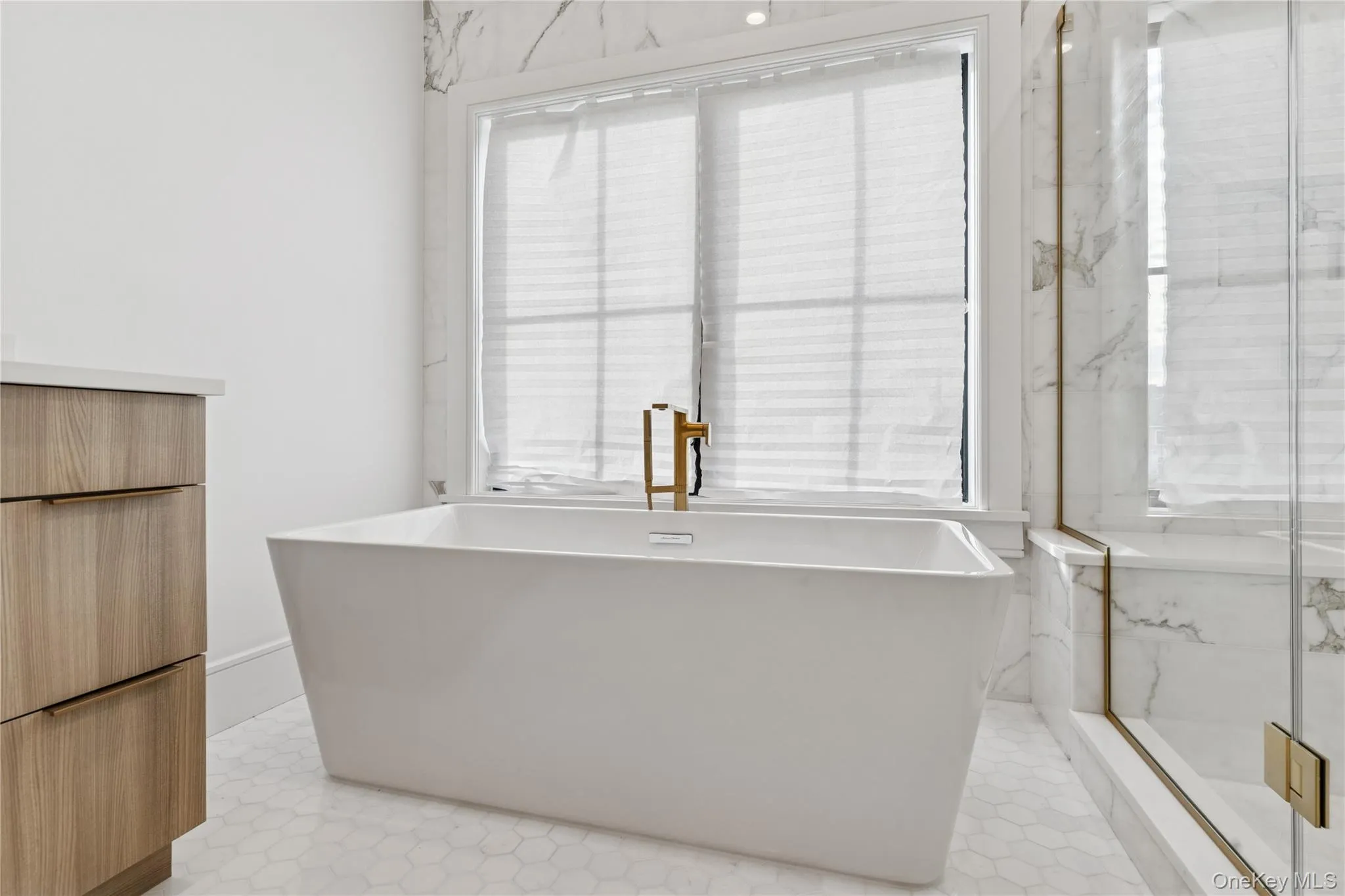 Full primary bathroom with a freestanding bath, a marble finish shower, and vanity Full primary bathroom with a freestanding bath, a marble finish shower, and vanity