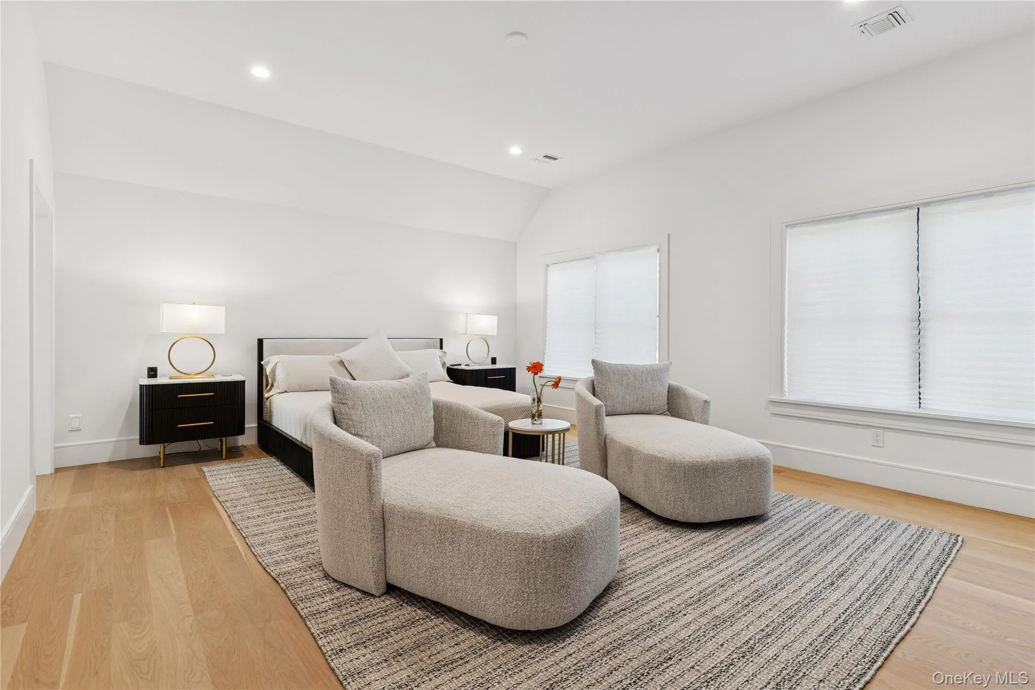 Bedroom with light wood-style floors, vaulted ceiling, and recessed lighting Bedroom with light wood-style floors, vaulted ceiling, and recessed lighting