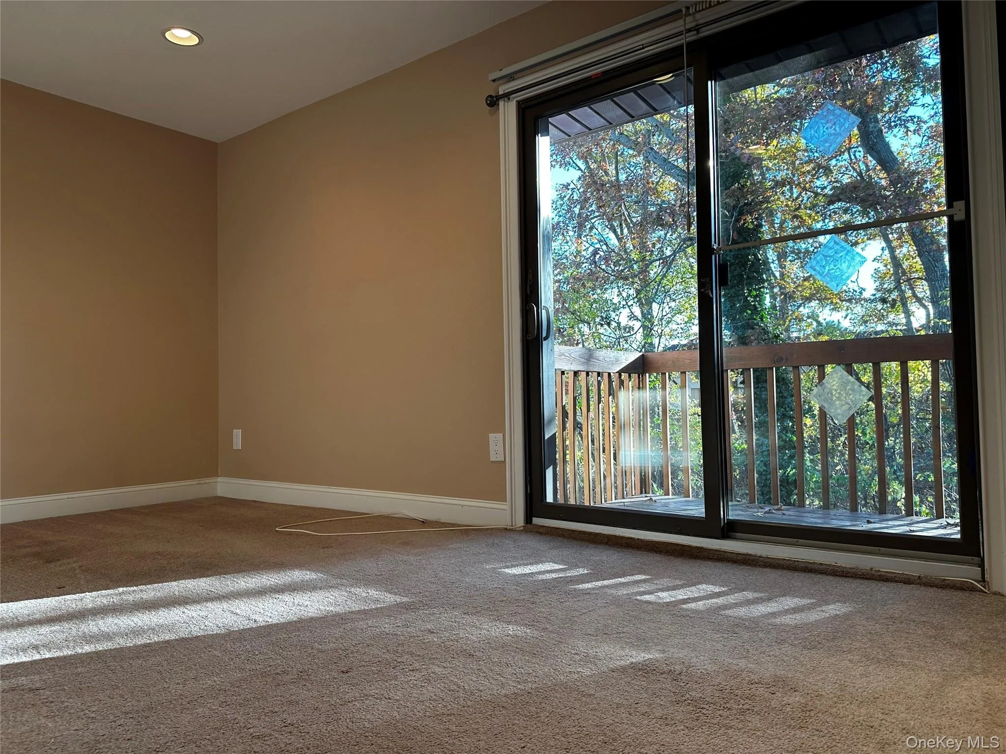 Bedroom featuring carpet and recessed lighting and sliding doors to private balcony. Bedroom featuring carpet and recessed lighting and sliding doors to private balcony.