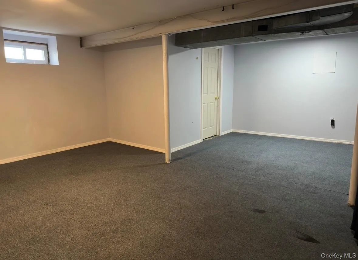 Basement featuring dark carpet and baseboards Basement featuring dark carpet and baseboards