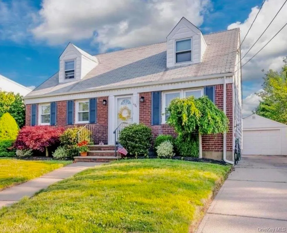Cape cod home with an outdoor structure, brick siding, a garage, and a front yard Cape cod home with an outdoor structure, brick siding, a garage, and a front yard