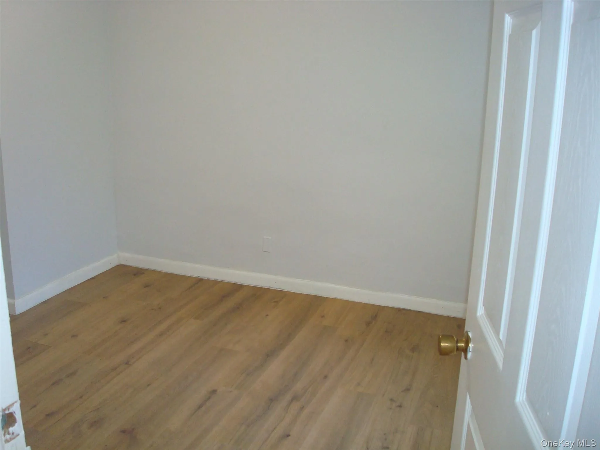 Unfurnished room with wood finished floors and baseboards Unfurnished room with wood finished floors and baseboards