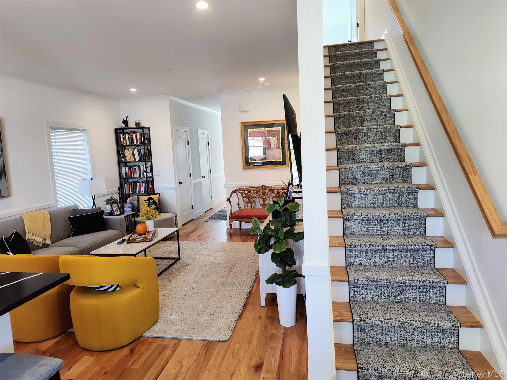 Stairway with wood finished floors, recessed lighting, and crown molding Stairway with wood finished floors, recessed lighting, and crown molding