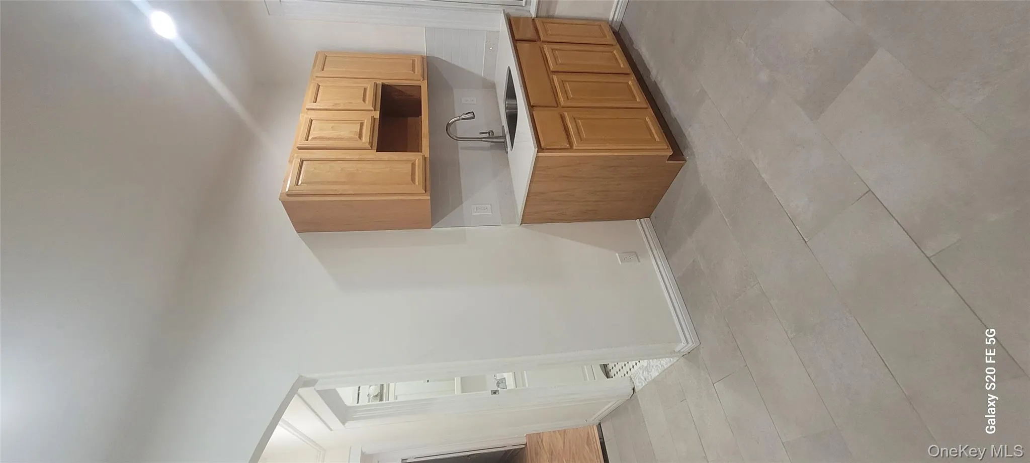 Kitchen with light countertops, light brown cabinets, and light tile patterned floors Kitchen with light countertops, light brown cabinets, and light tile patterned floors