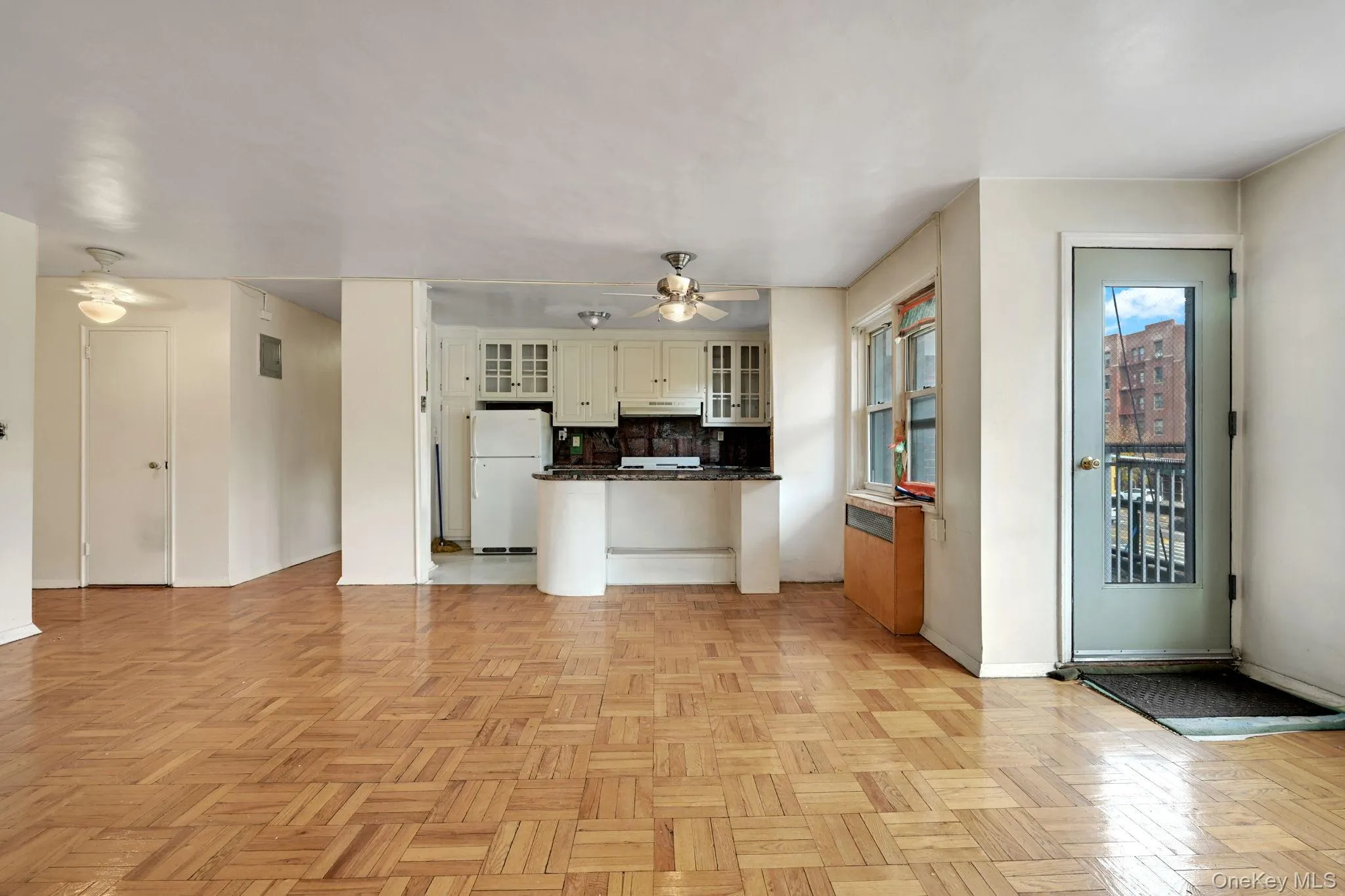 Kitchen with dark countertops, decorative backsplash, open floor plan, freestanding refrigerator, and glass insert cabinets Kitchen with dark countertops, decorative backsplash, open floor plan, freestanding refrigerator, and glass insert cabinets