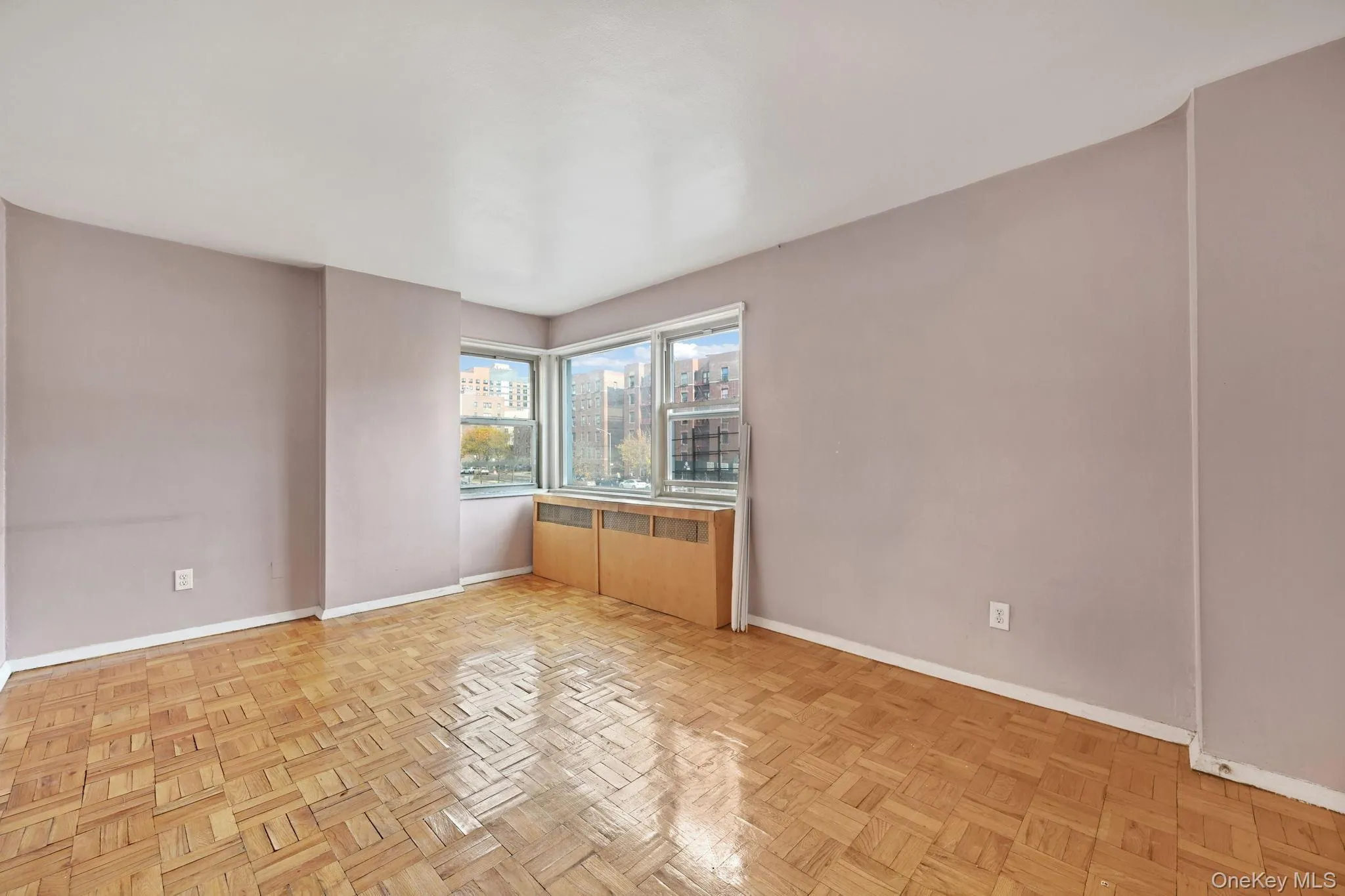 Unfurnished room featuring radiator heating unit and a city view Unfurnished room featuring radiator heating unit and a city view