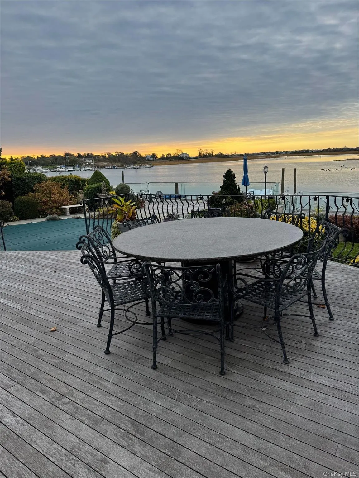 Wooden terrace with outdoor dining area and a water view Wooden terrace with outdoor dining area and a water view