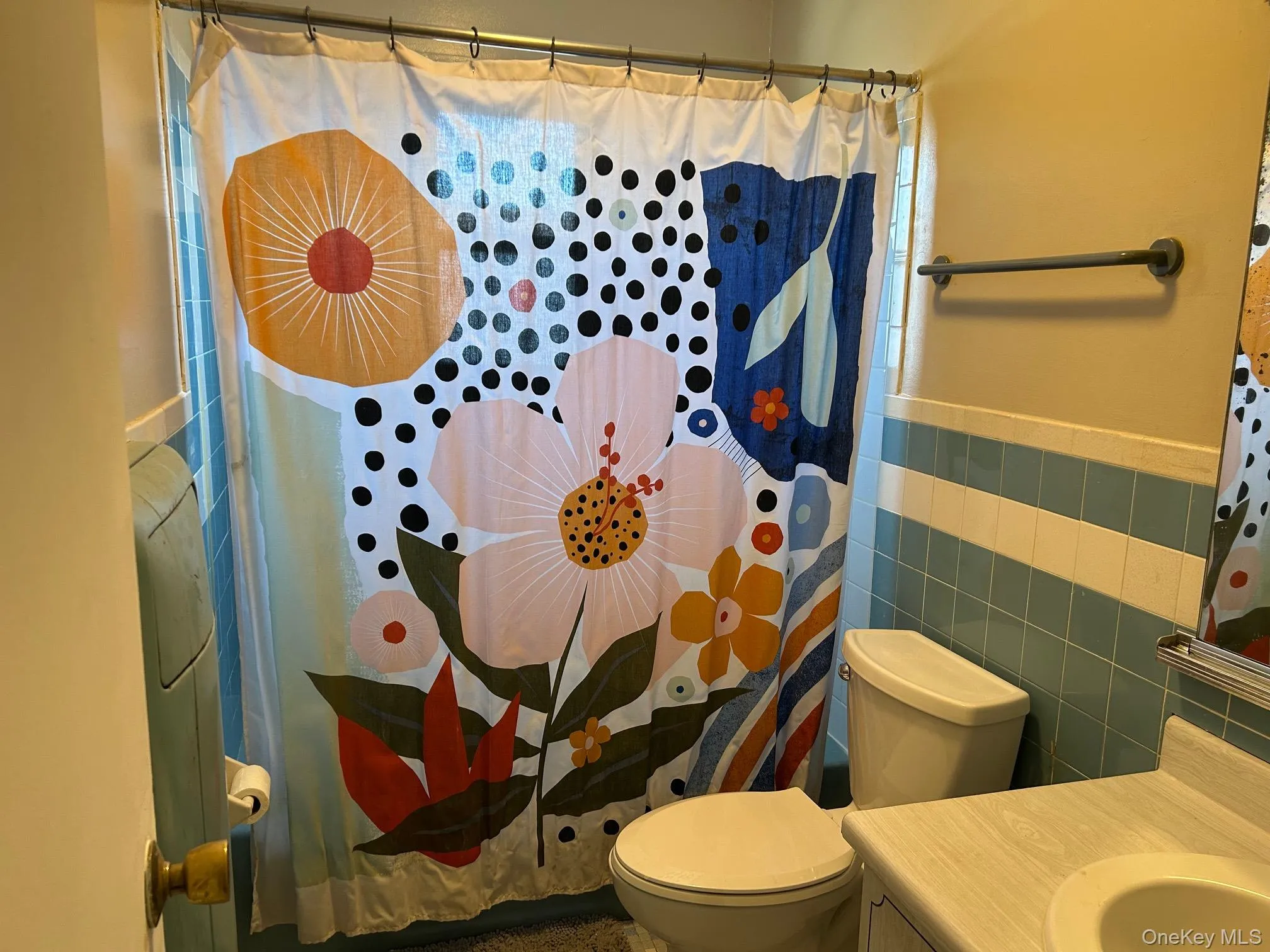 Bathroom with tile walls, vanity, and a wainscoted wall Bathroom with tile walls, vanity, and a wainscoted wall