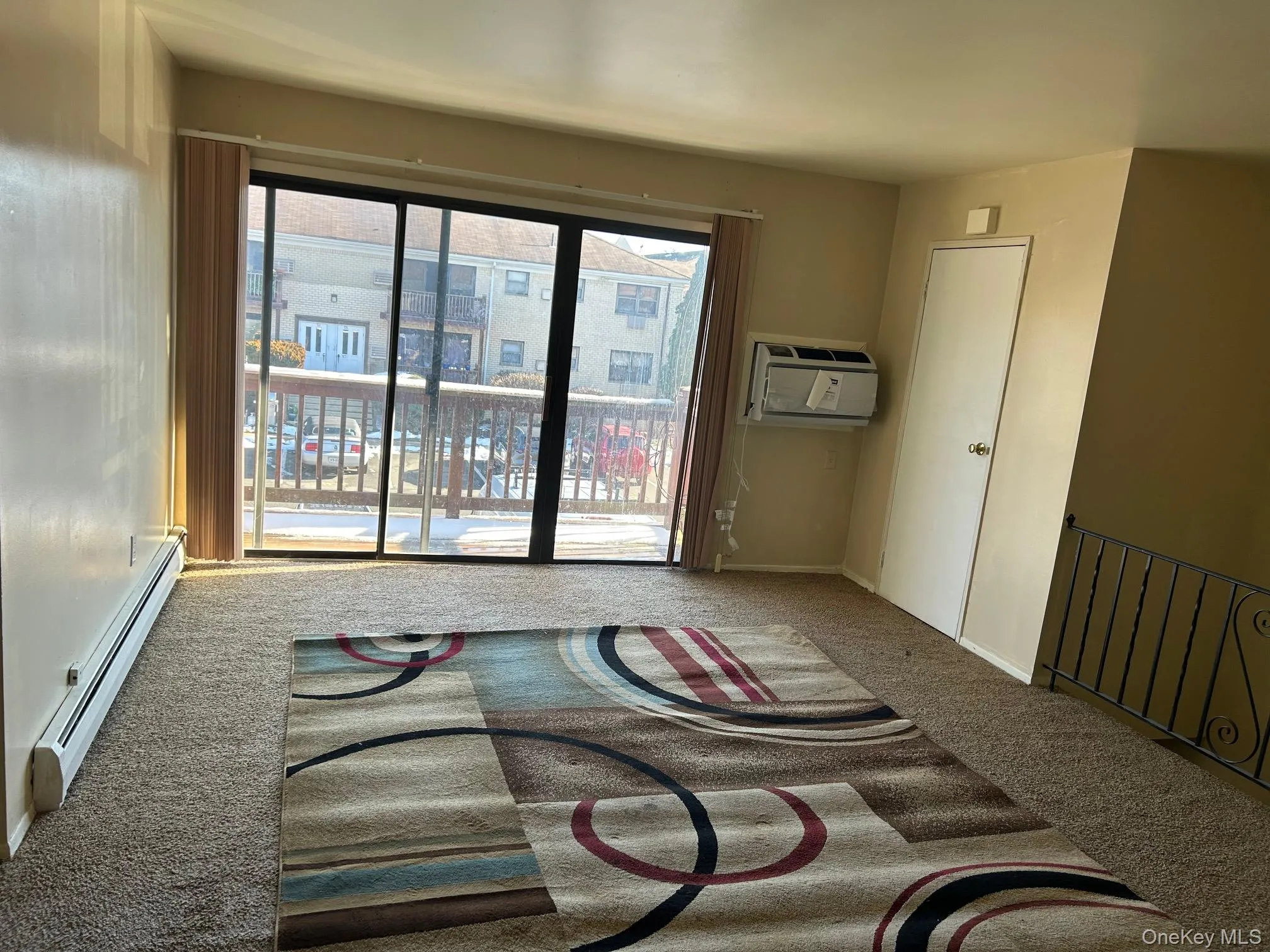 Empty room featuring a baseboard radiator and carpet flooring Empty room featuring a baseboard radiator and carpet flooring