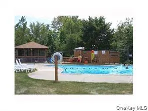 Community pool featuring a patio area and view of wooded area Community pool featuring a patio area and view of wooded area