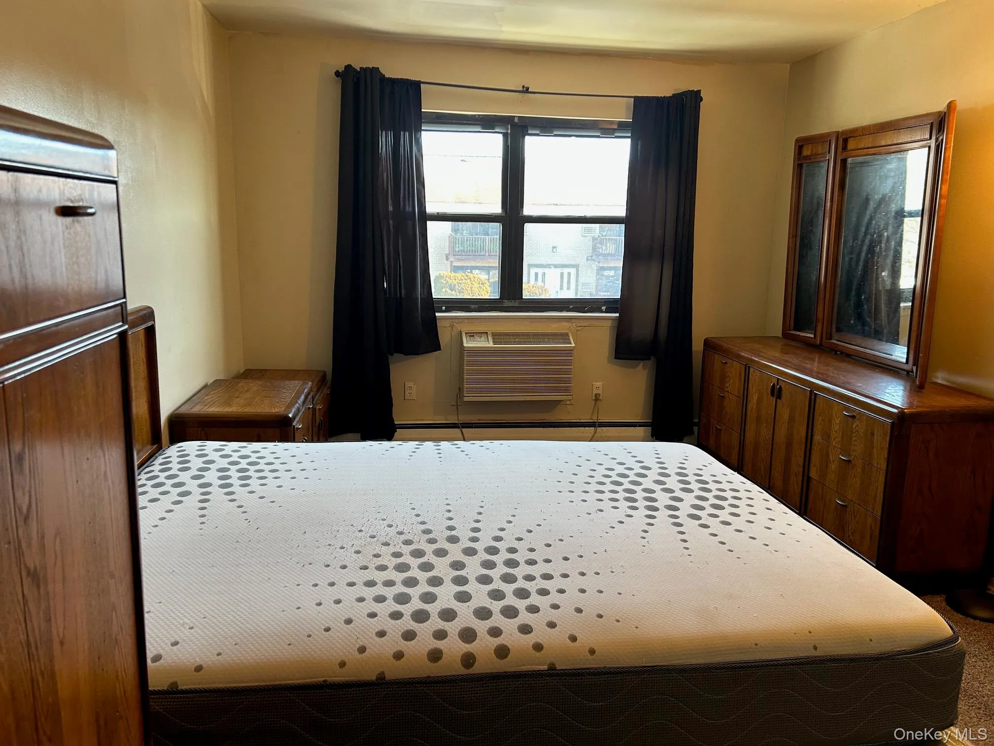 Bedroom featuring a wall mounted AC and a baseboard heating unit Bedroom featuring a wall mounted AC and a baseboard heating unit