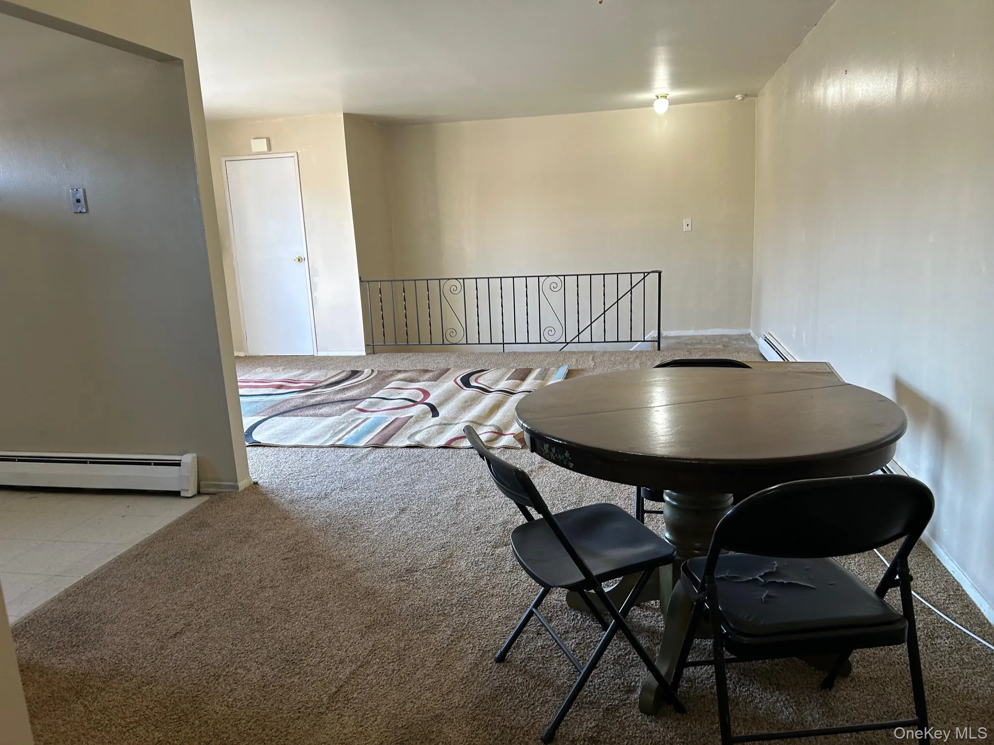 Dining space featuring light carpet and baseboard heating Dining space featuring light carpet and baseboard heating