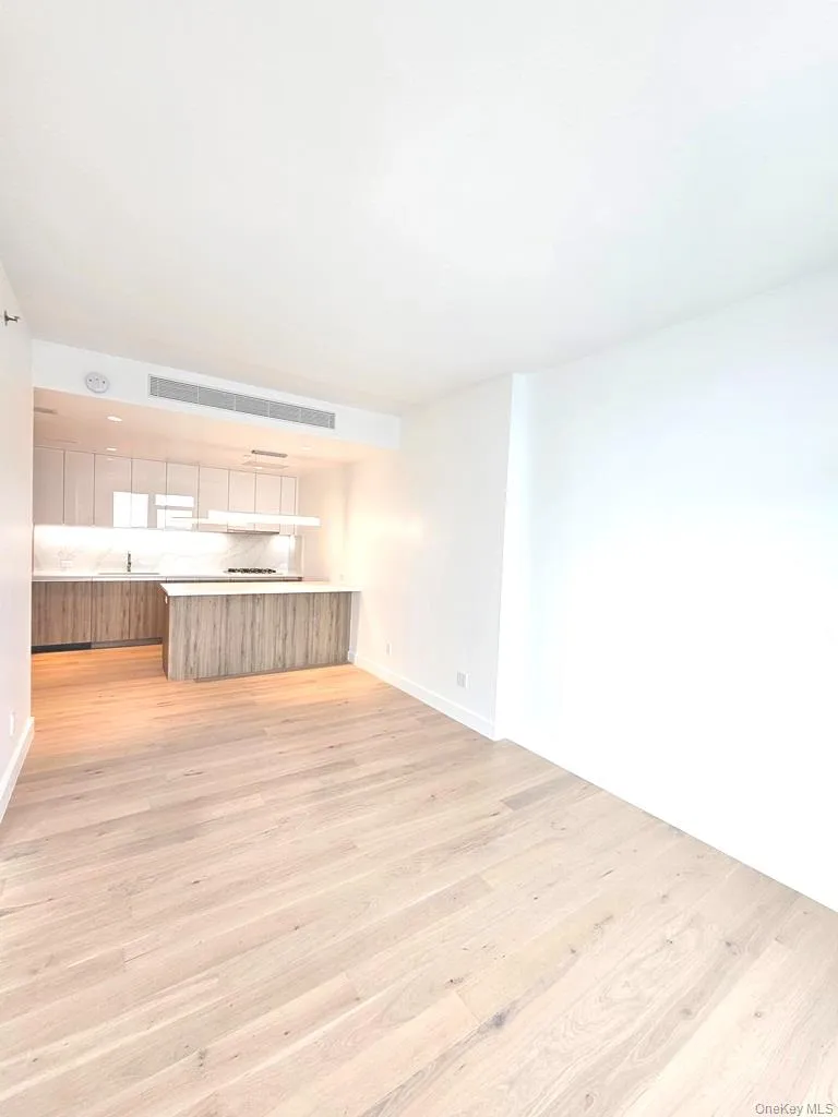 Unfurnished living room with light wood-style flooring and baseboards Unfurnished living room with light wood-style flooring and baseboards