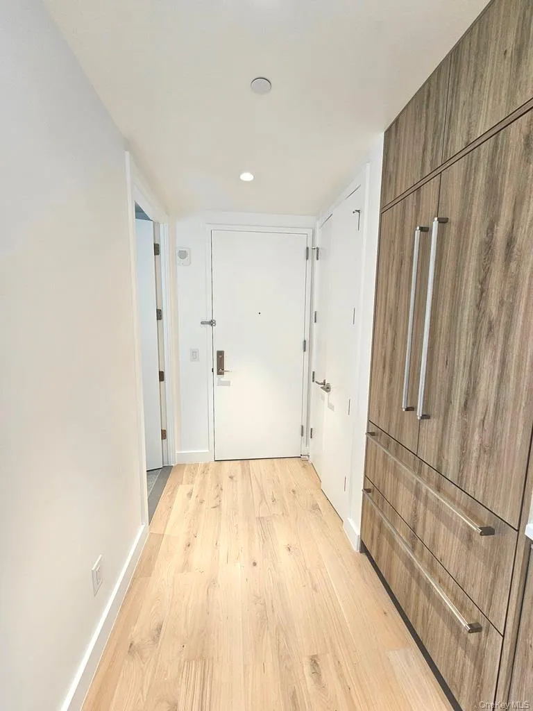 Hallway featuring light wood finished floors and recessed lighting Hallway featuring light wood finished floors and recessed lighting