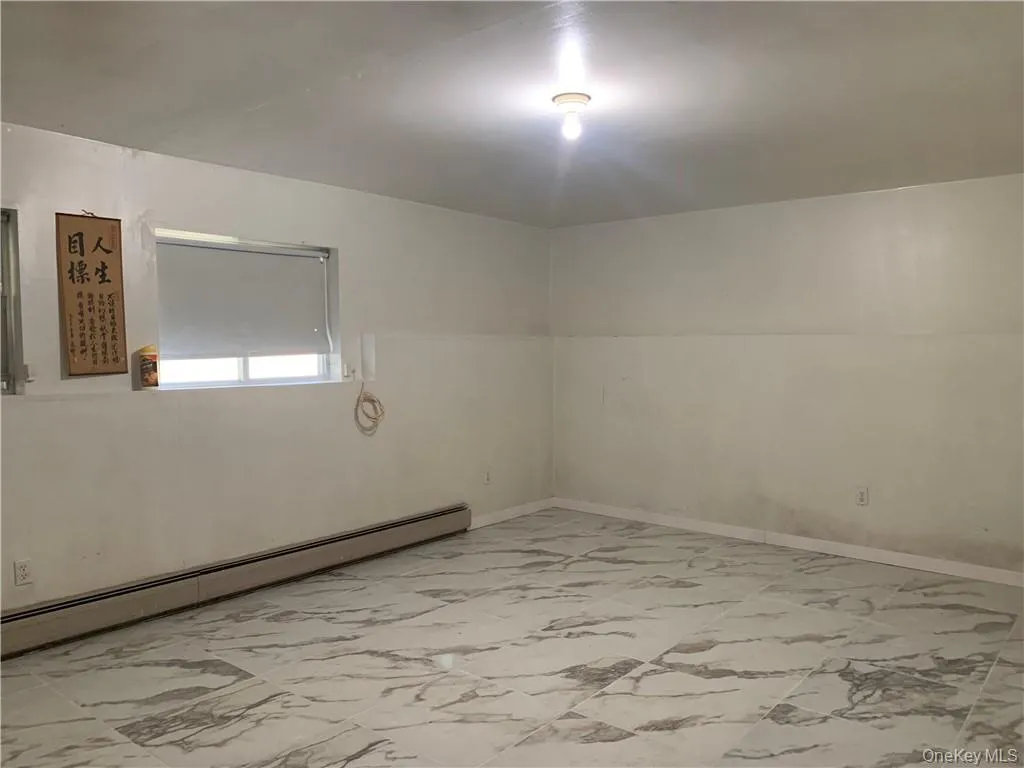 Empty room with lofted ceiling and a baseboard radiator Empty room with lofted ceiling and a baseboard radiator