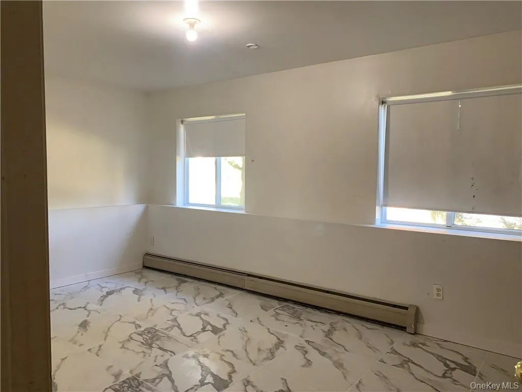 Unfurnished room featuring baseboard heating Unfurnished room featuring baseboard heating