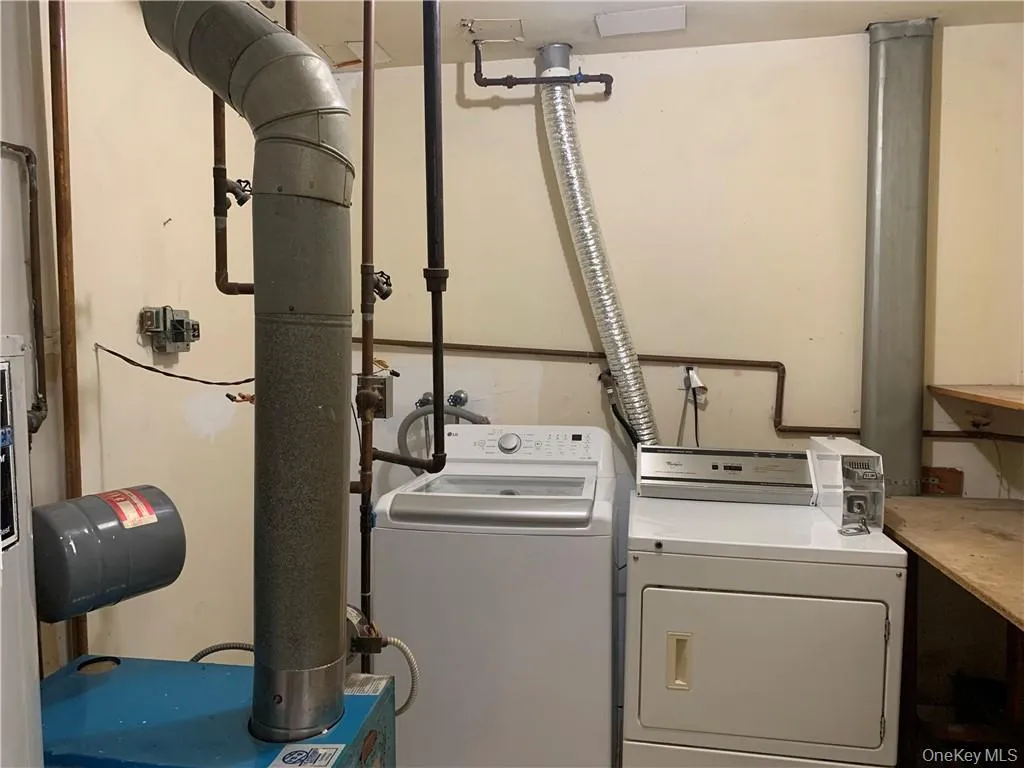 Laundry room featuring washer and dryer and water heater Laundry room featuring washer and dryer and water heater