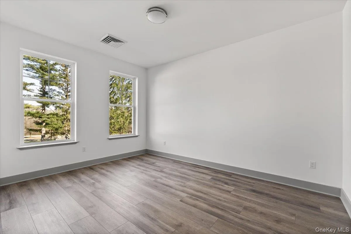 Spare room with wood finished floors and baseboards Spare room with wood finished floors and baseboards