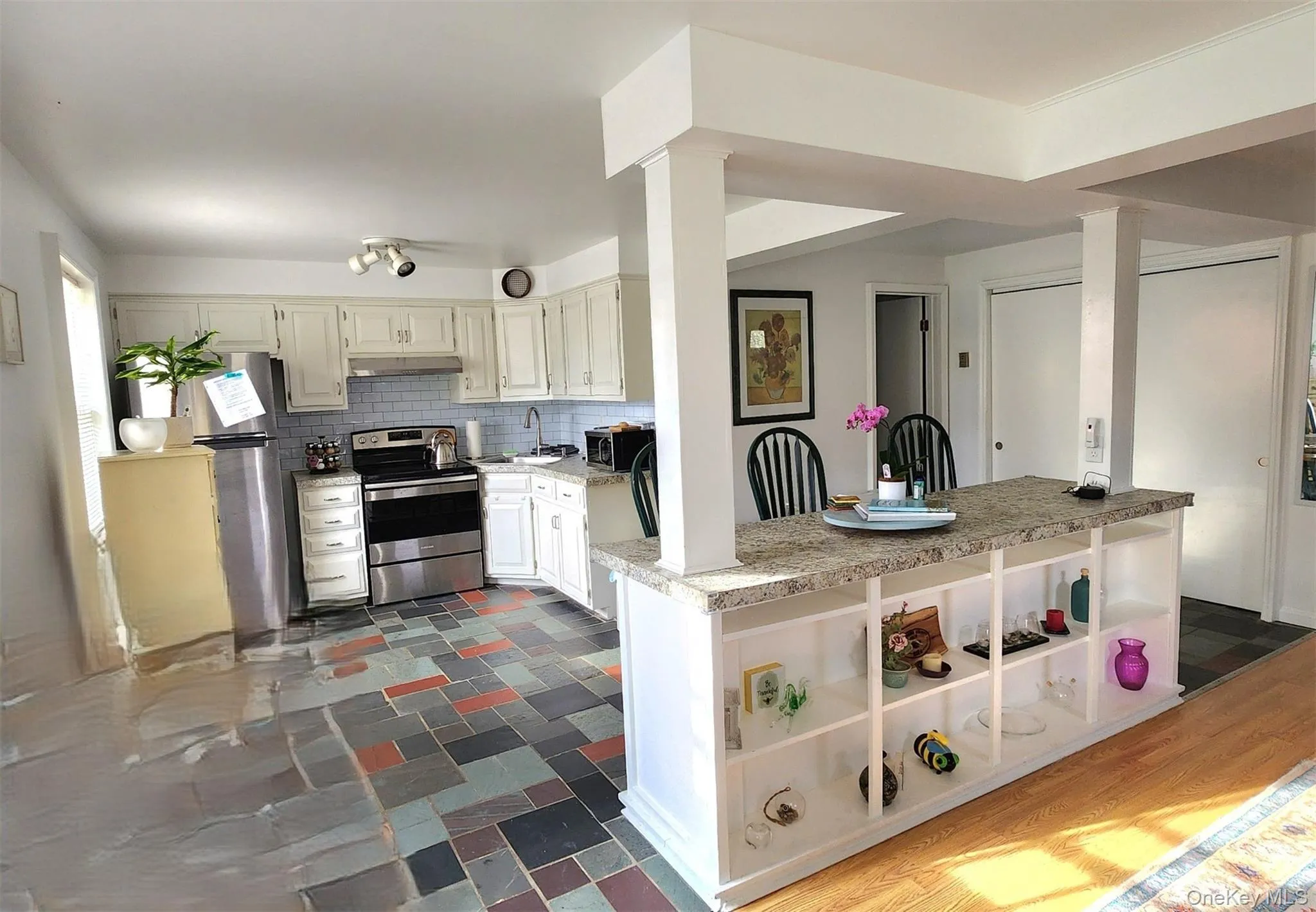 Kitchen featuring appliances with stainless steel finishes, backsplash, light countertops, open shelves, and under cabinet range hood Kitchen featuring appliances with stainless steel finishes, backsplash, light countertops, open shelves, and under cabinet range hood