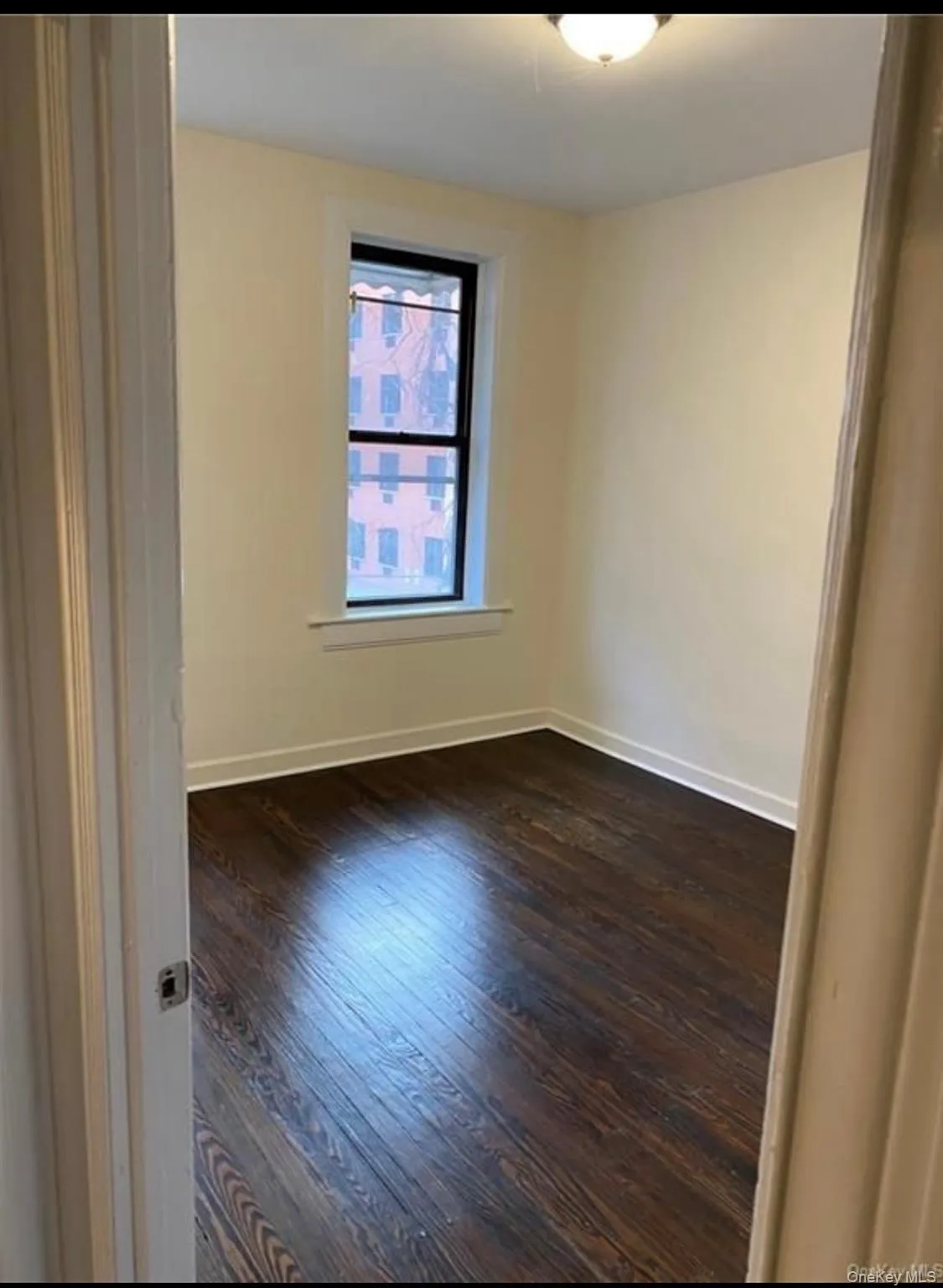 Spare room featuring dark wood-style flooring and baseboards Spare room featuring dark wood-style flooring and baseboards