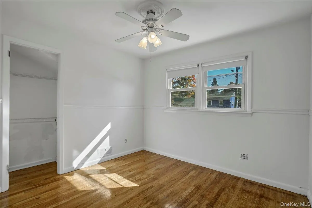 Empty room featuring hardwood / wood-style flooring and ceiling fan Empty room featuring hardwood / wood-style flooring and ceiling fan