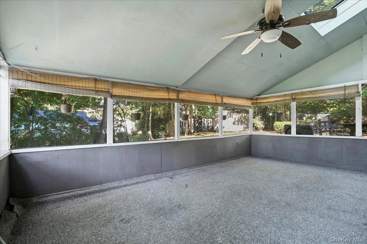 Unfurnished sunroom with vaulted ceiling and ceiling fan Unfurnished sunroom with vaulted ceiling and ceiling fan