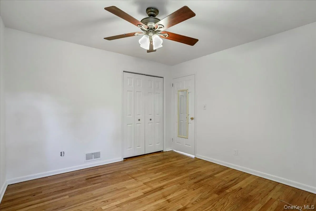 Empty room with light hardwood / wood-style floors and ceiling fan Empty room with light hardwood / wood-style floors and ceiling fan