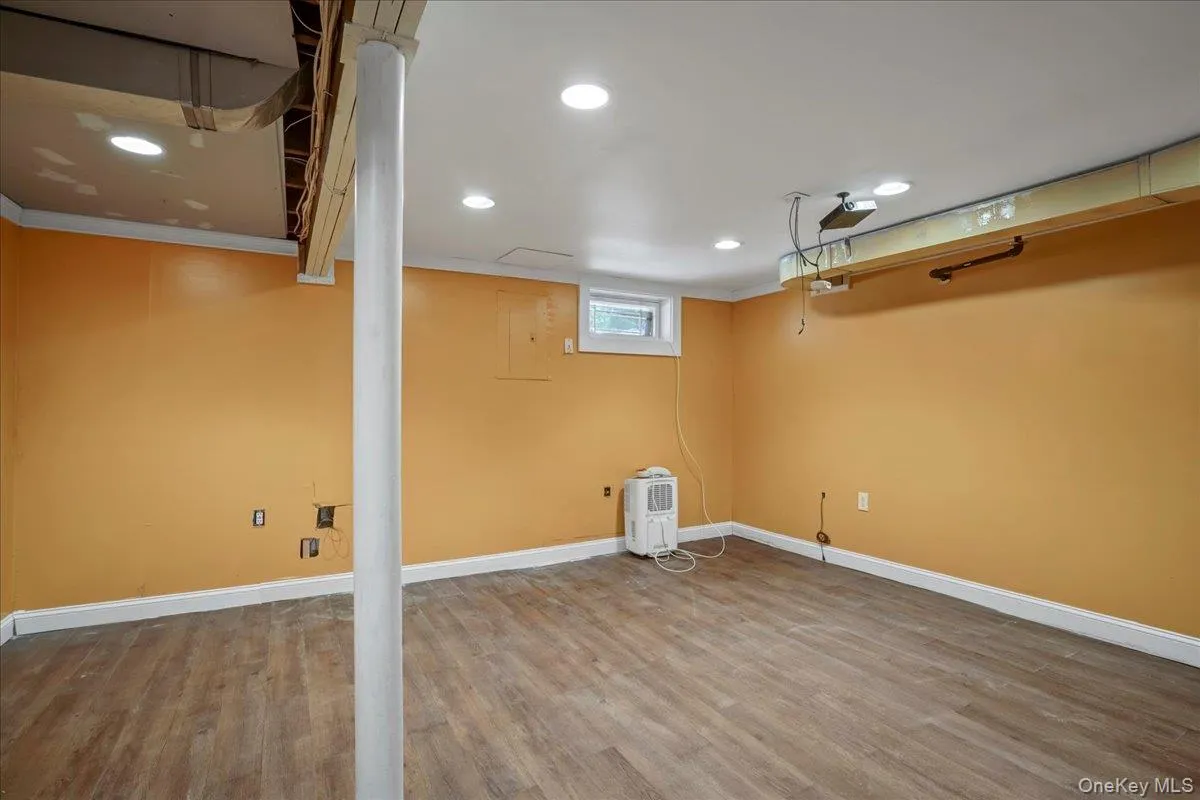Basement with crown molding and hardwood / wood-style floors Basement with crown molding and hardwood / wood-style floors