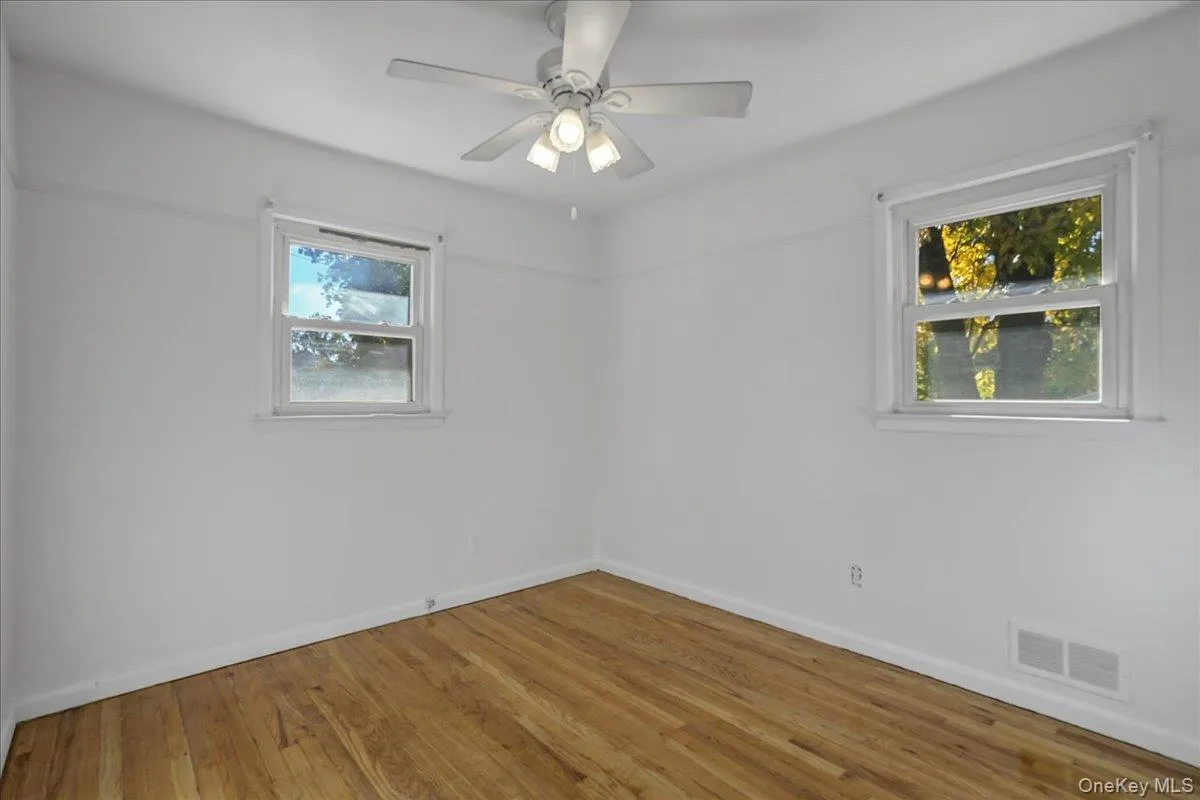 Spare room featuring ceiling fan and wood-type flooring Spare room featuring ceiling fan and wood-type flooring